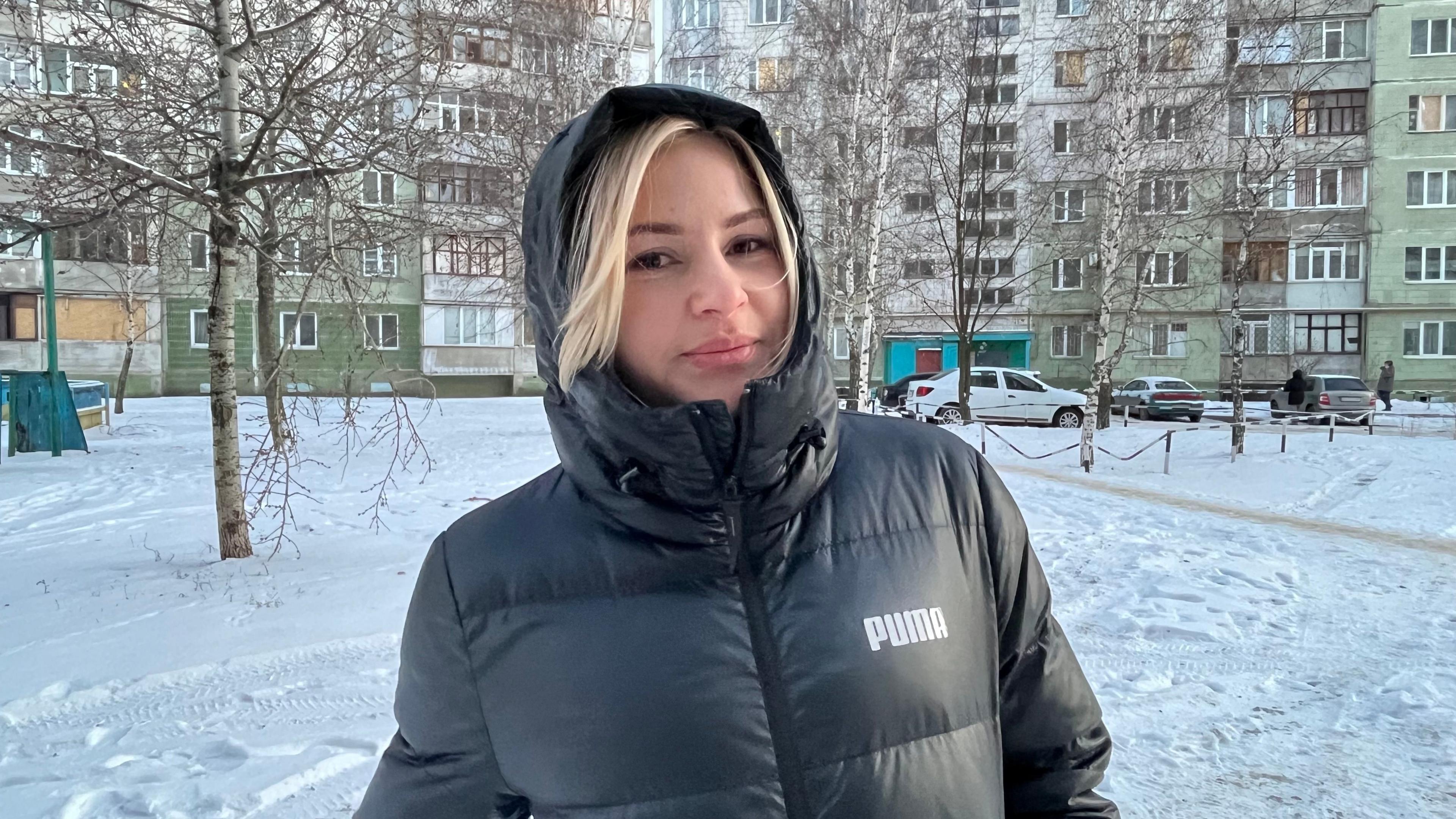 Yuliia, a young woman in front of some residential buildings