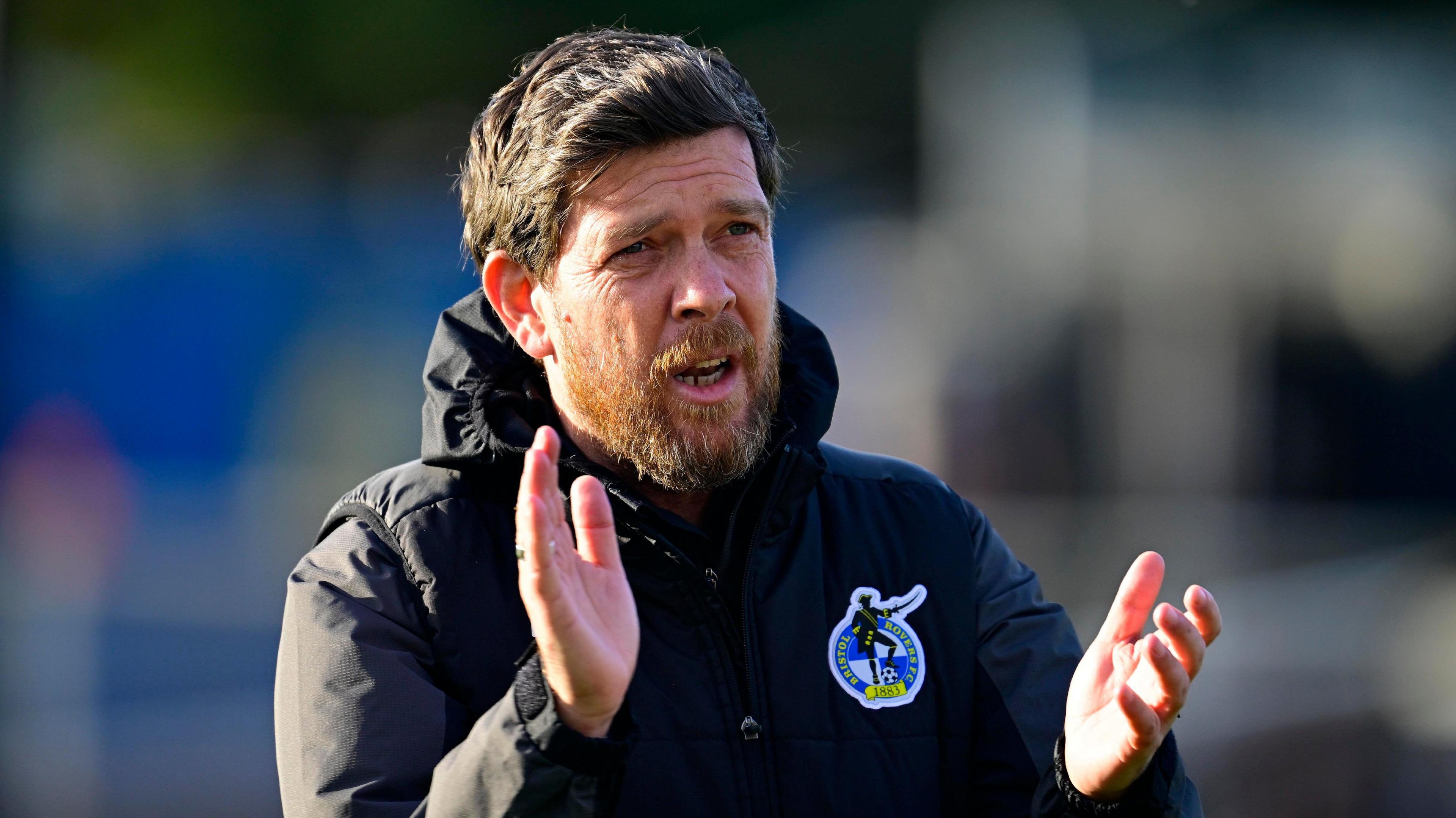 Darrell Clarke claps towards fans while walking on the pitch