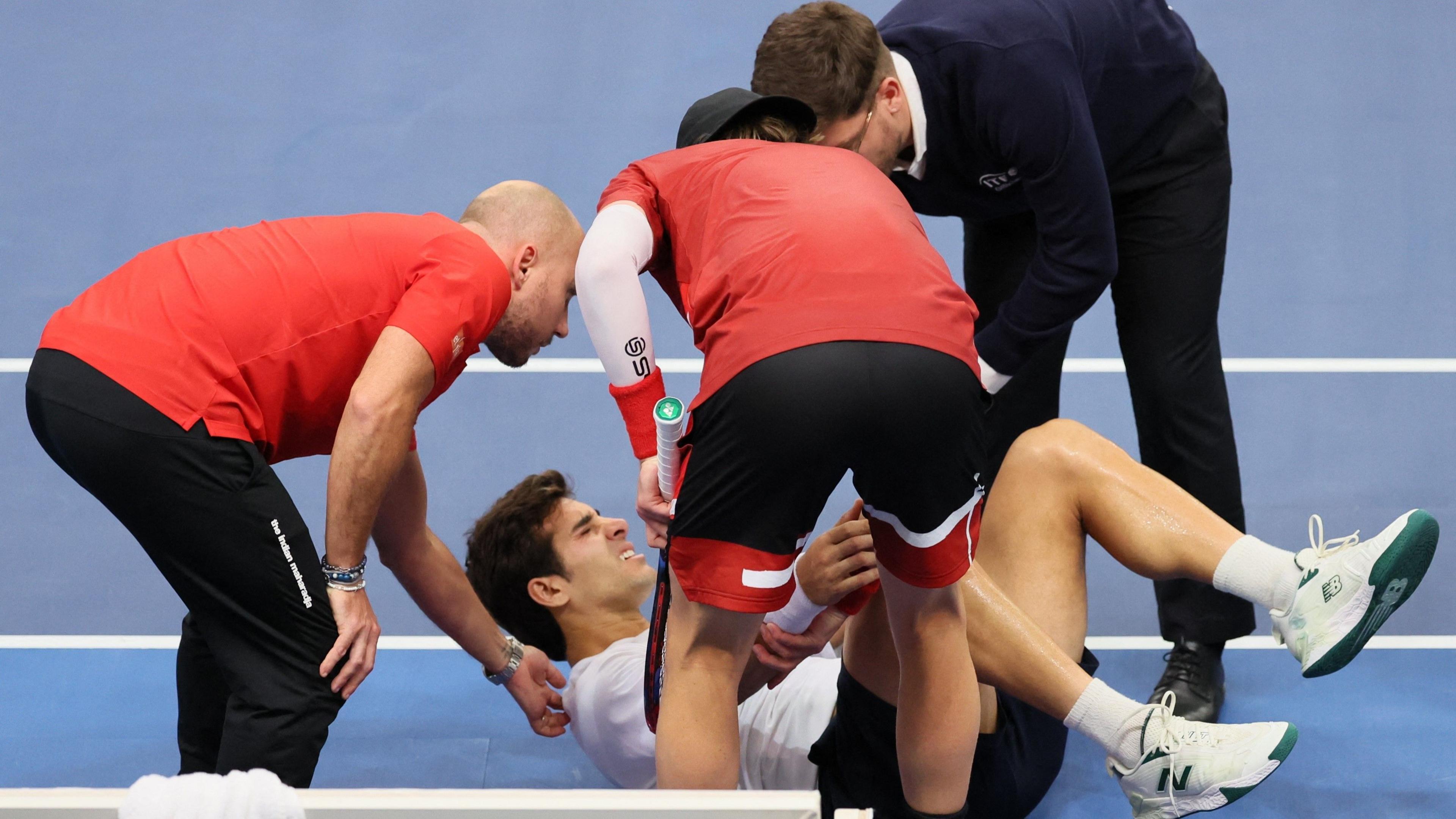 Chile's Cristian Garin is helped by team members 