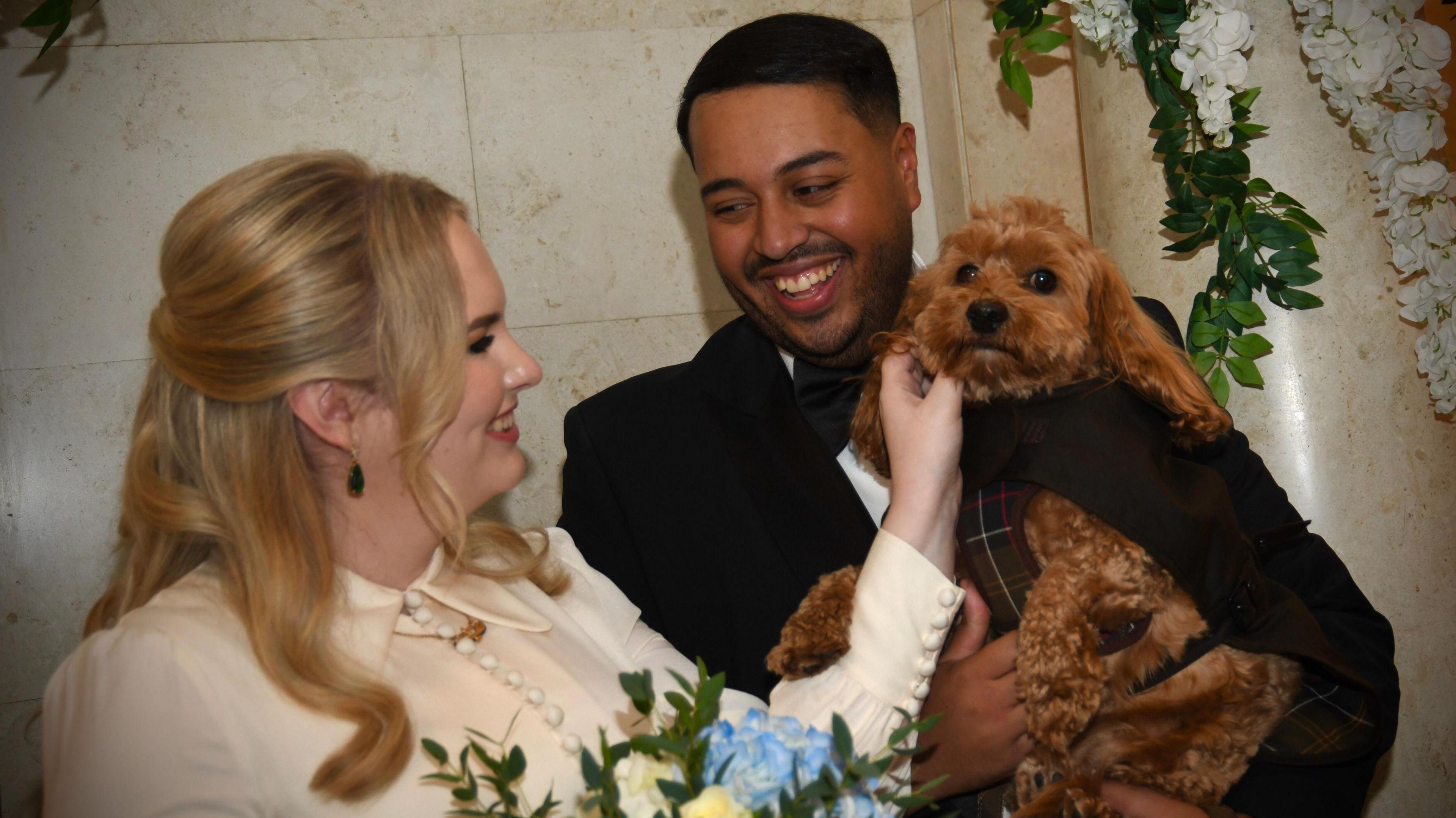 Daisy McKinley strokes dog Marvin who is clutched in the arms of Dan McKinley after the pair had just been married