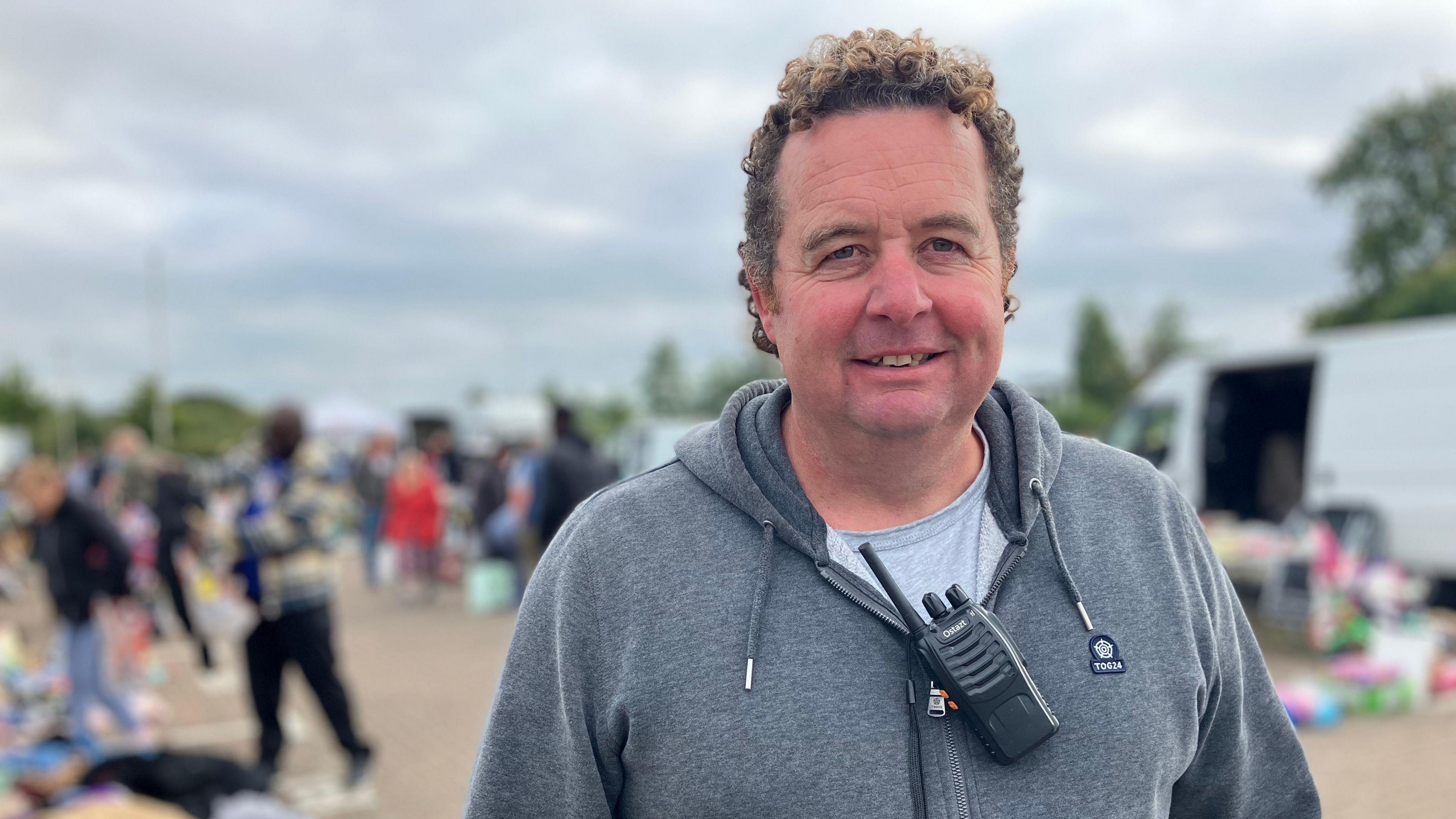 Reginald Daldry standing wearing a grey hoodie at a car boot sale in Gloucester