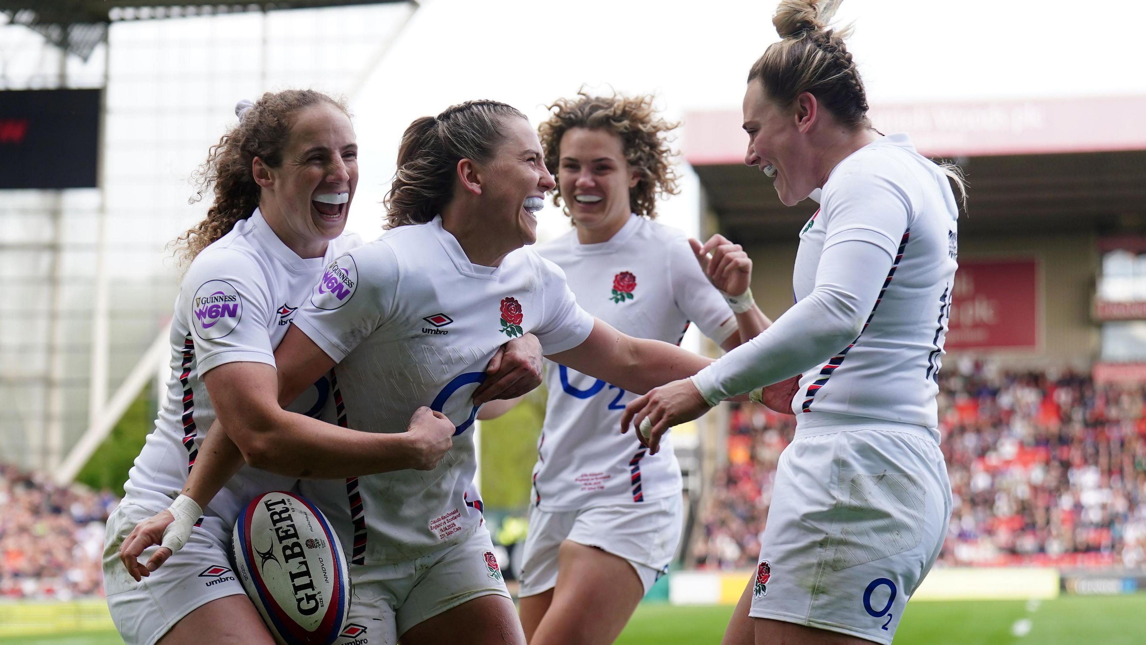 England's Claudia MacDonald celebrates with teammates after scoring a try. 