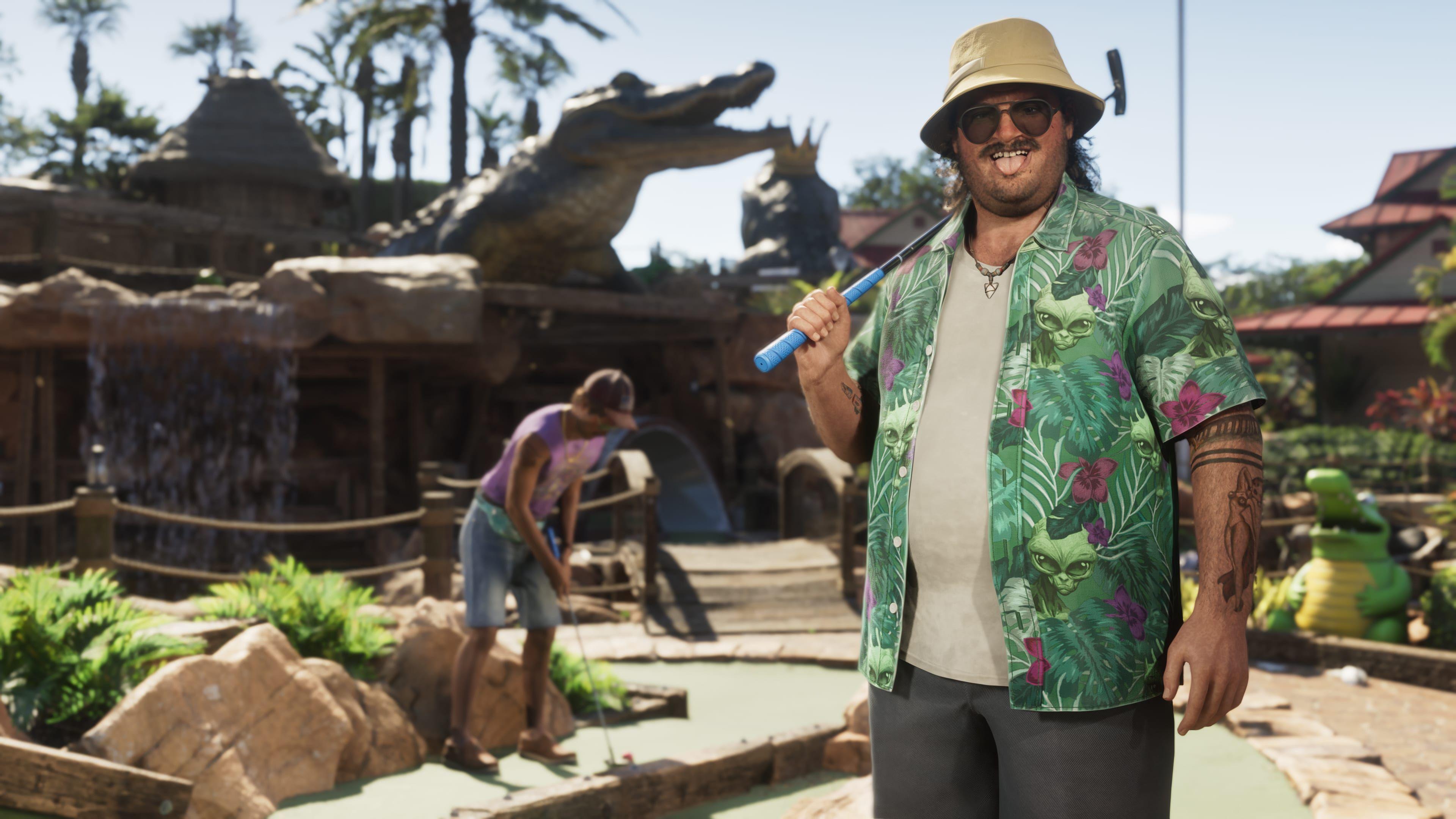 Cal Hampton, a character from GTA 6, stands in front of an alligator-themed crazy golf course. He holds a putter over one shoulder, and pulls a tongue-out face at the viewer. His loud, green, floral shirt stands out against the browns of the golf course. Behind him, a companion can be seen lining up an attempted putt, while a large alligator statue looms over the course.