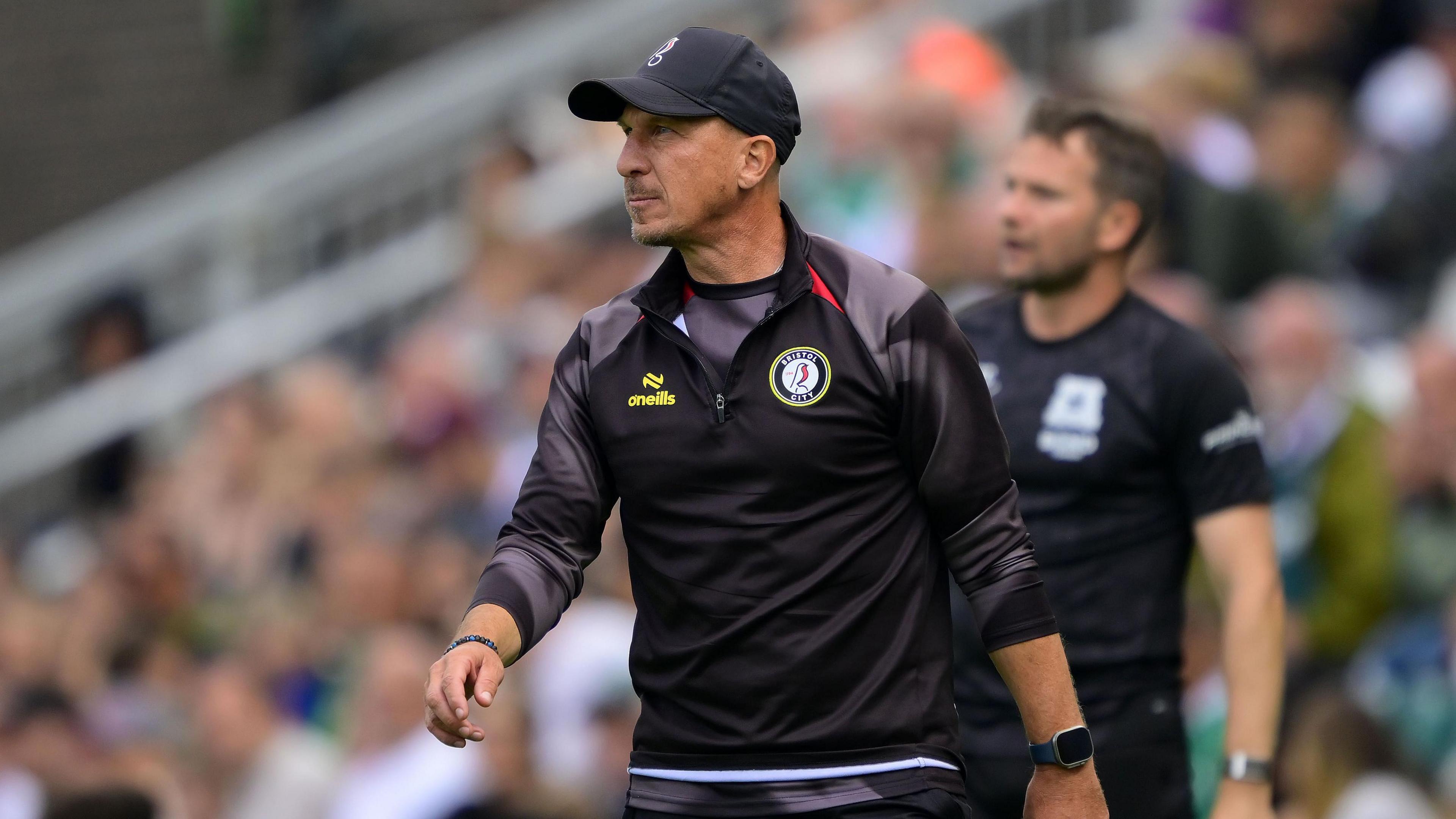 Gerhard Struber wearing a Bristol City cap and top watches on from the sidelines during a pre-season game