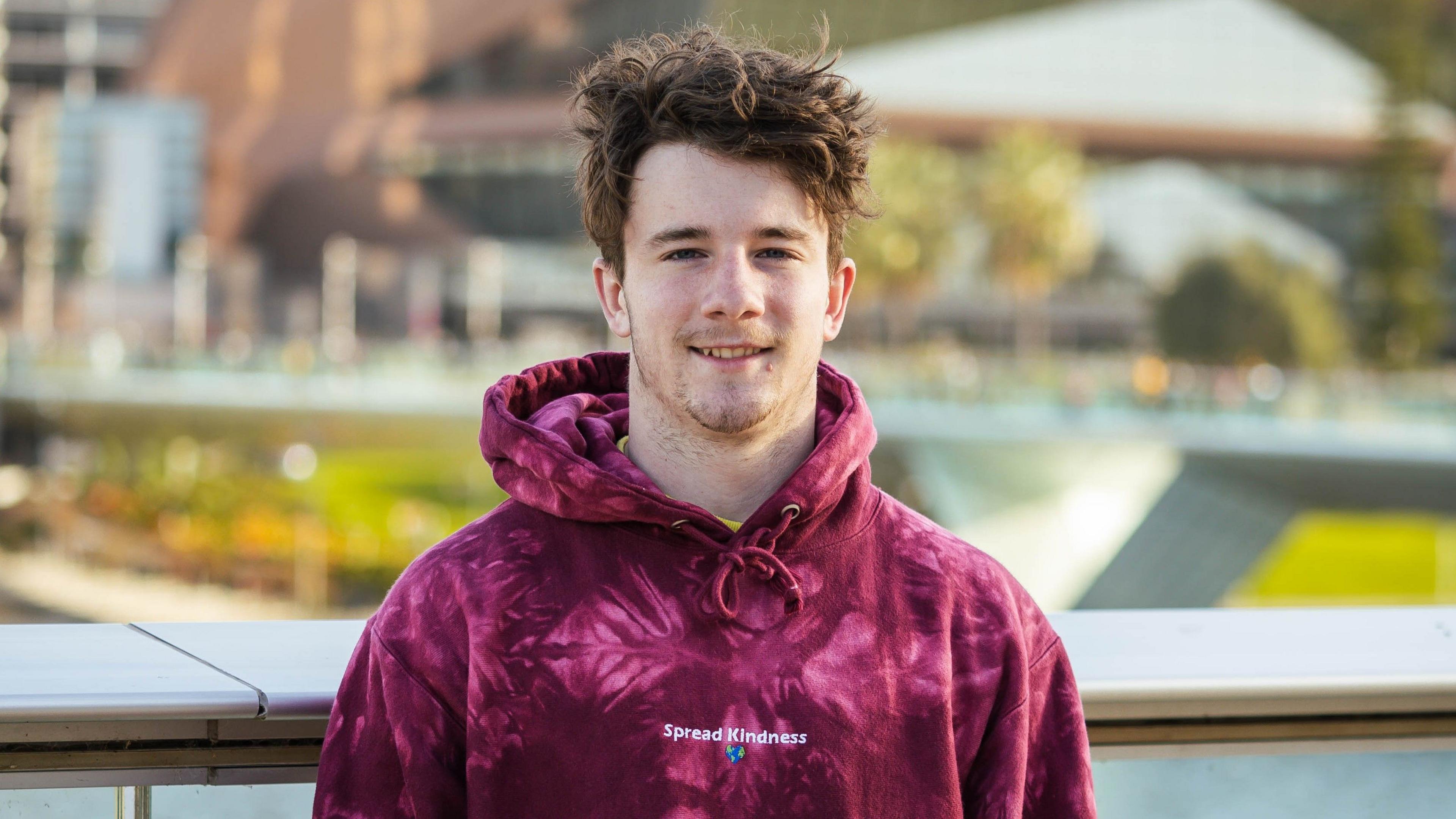 Samuel Weidenhofer wearing a deep red hoodie.