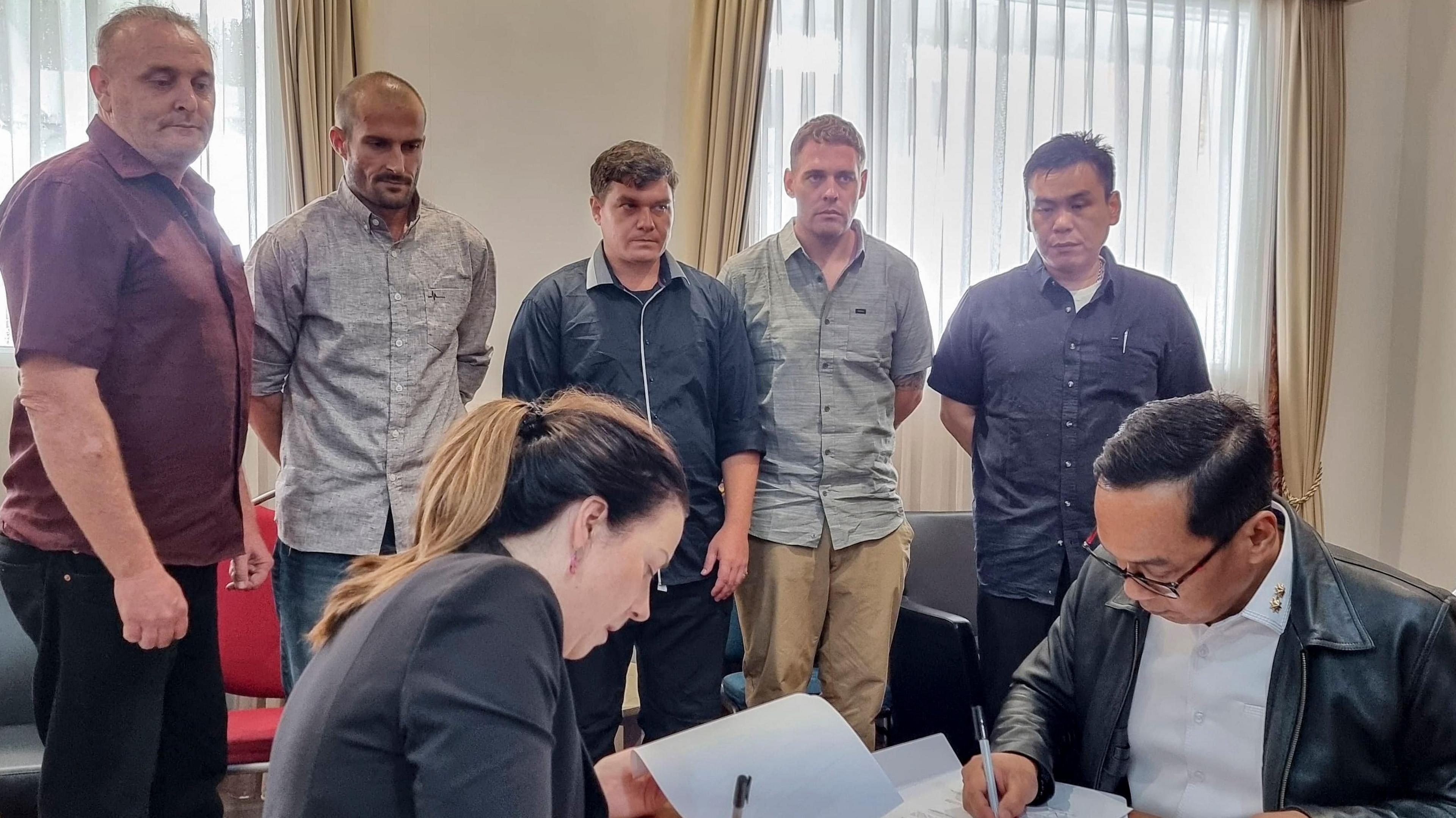 'Bali Nine' (L-R, background) Martin Eric Stephens, Michael William Czugaj, Scott Anthony Rush, Matthew James Norman and Si Yi Chen inside a room in Bali International Airport during a handover process for their return