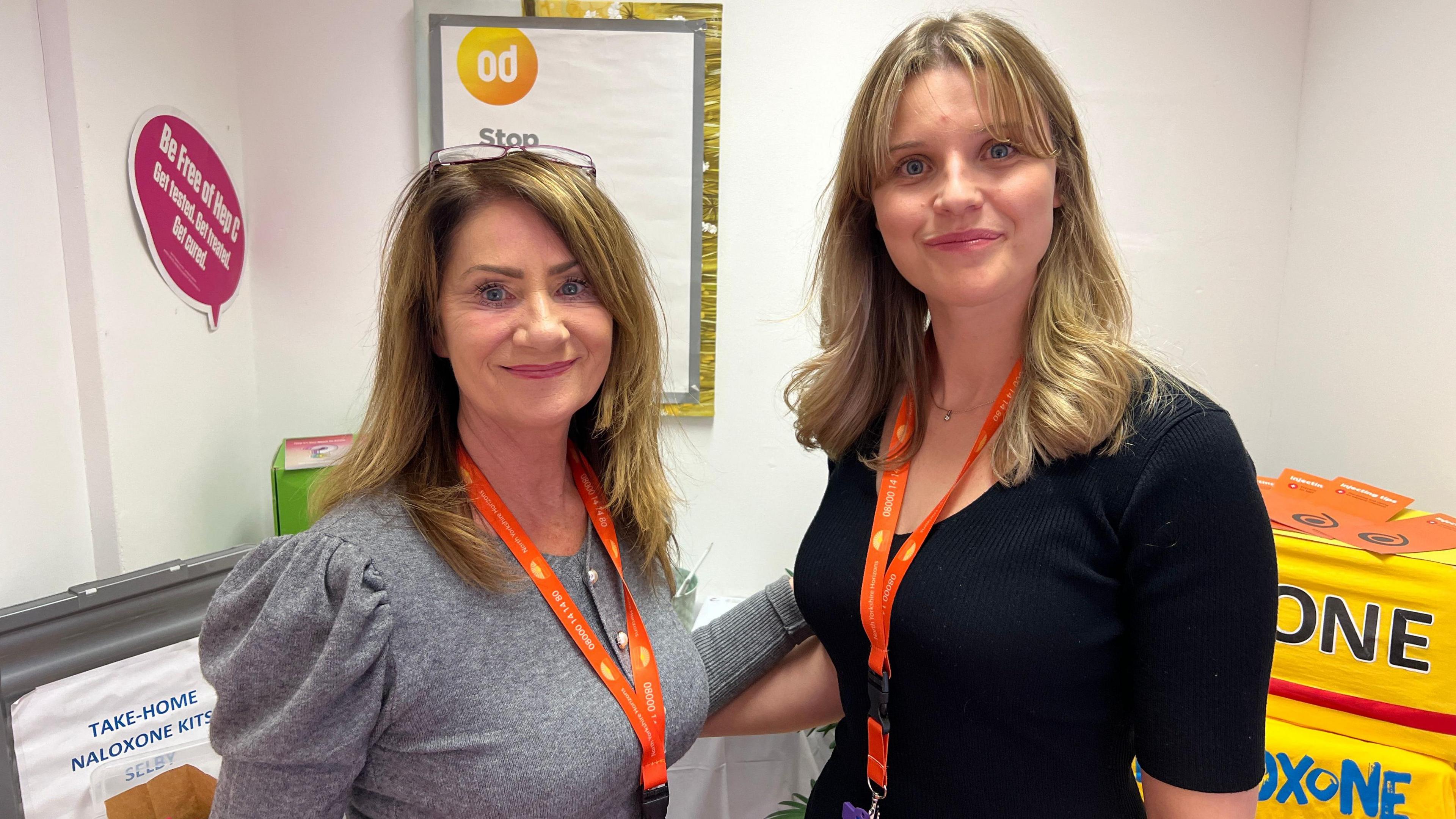 Sam Thomson and Sarah Rogers from North Yorkshire Horizons look straight towards the camera. Sam is wearing a grey top, Sarah is wearing a black top. They have orange lanyards around their necks.