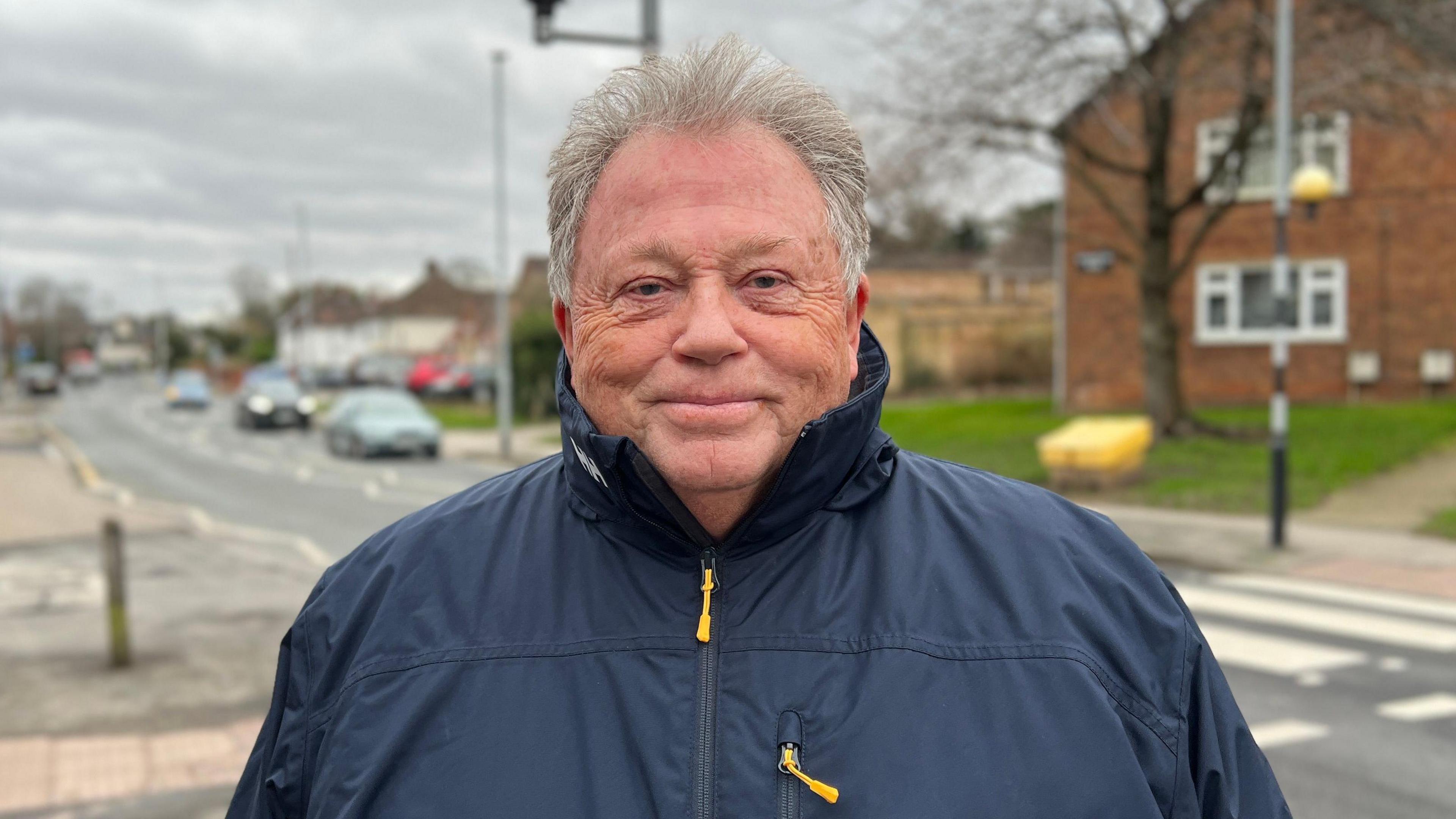 Man looking into camera on street.