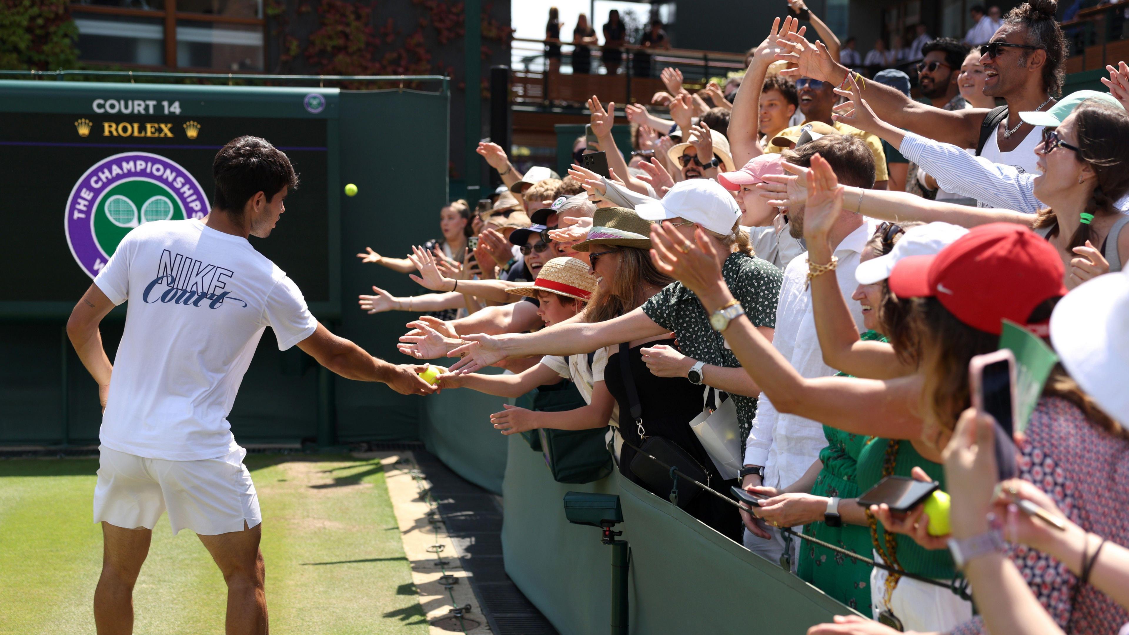 Carlos Alcaraz interacting with fans on court 14 before the Wimbledon final