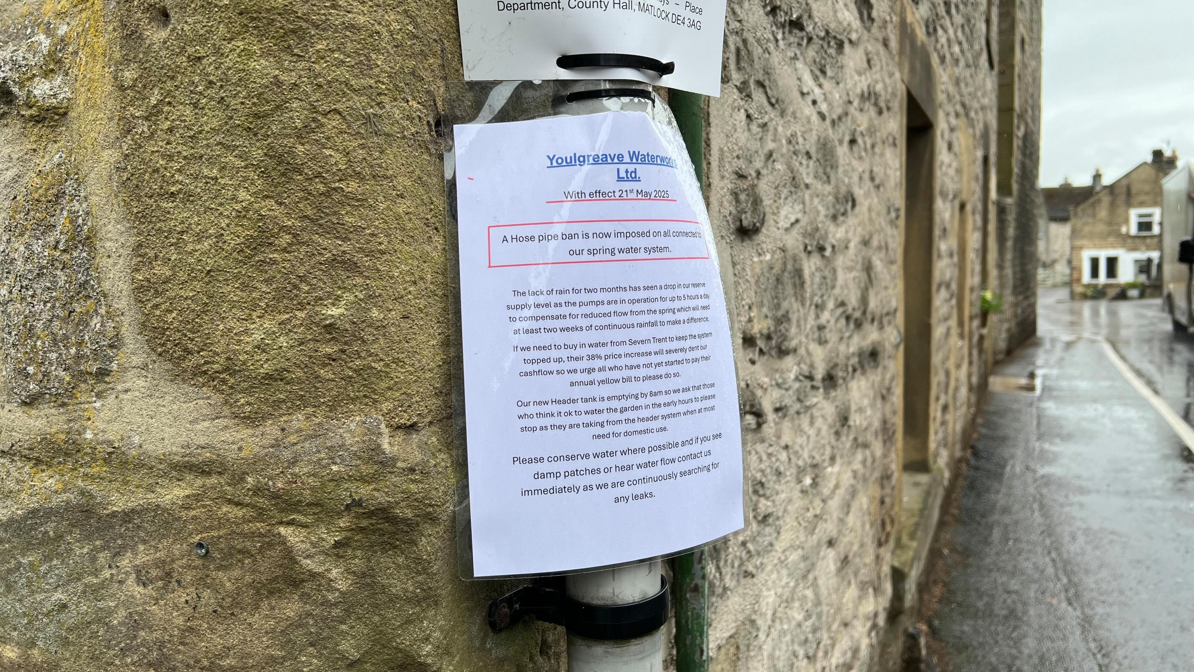 Image shows a sign put up in the village of Youlgreave in Derbyshire, reading: "The lack of rain for two months has seen a drop in our reserve supply level as the pumps are in operation for up to 5 hours a day to compensate for reduced flow from the spring which will need at least two weeks of continuous rainfall to make a difference.
If we need to buy in water from Severn Trent to keep the system topped up, their 38% price increase will severely dent our cashflow so we urge all who have not yet started to pay their annual yellow bill to please do so.
Our new Header tank is emptying by 8am so we ask that those who think it is ok to water the garden in the early hours to please stop as they are taking from the header system when at most need for domestic use.
Please conserve water where possible and if you see damp patches or hear water flow contact us immediately as we are continuously searching for any leaks."