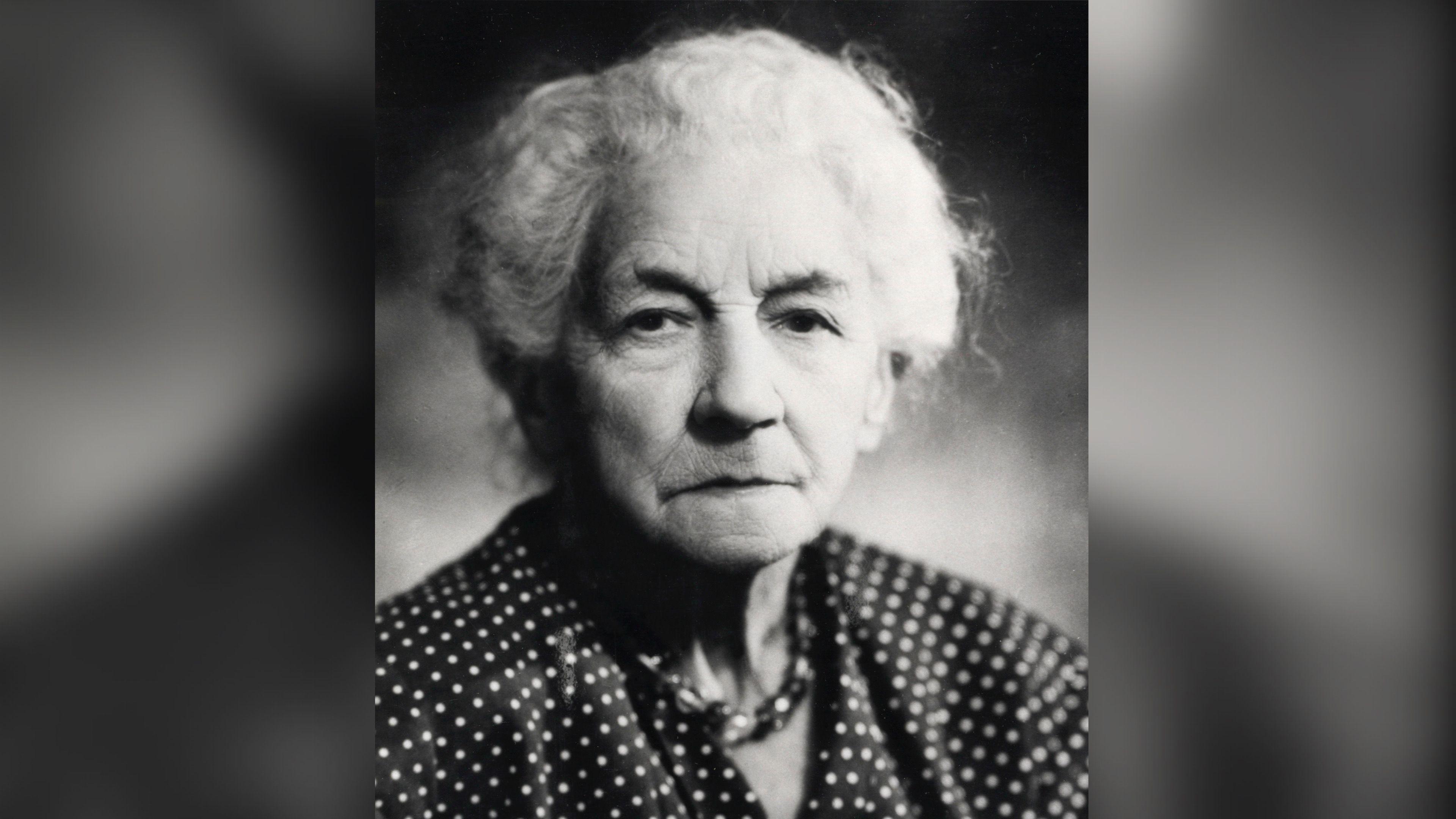 A black and white image of a woman in a polka dot shirt