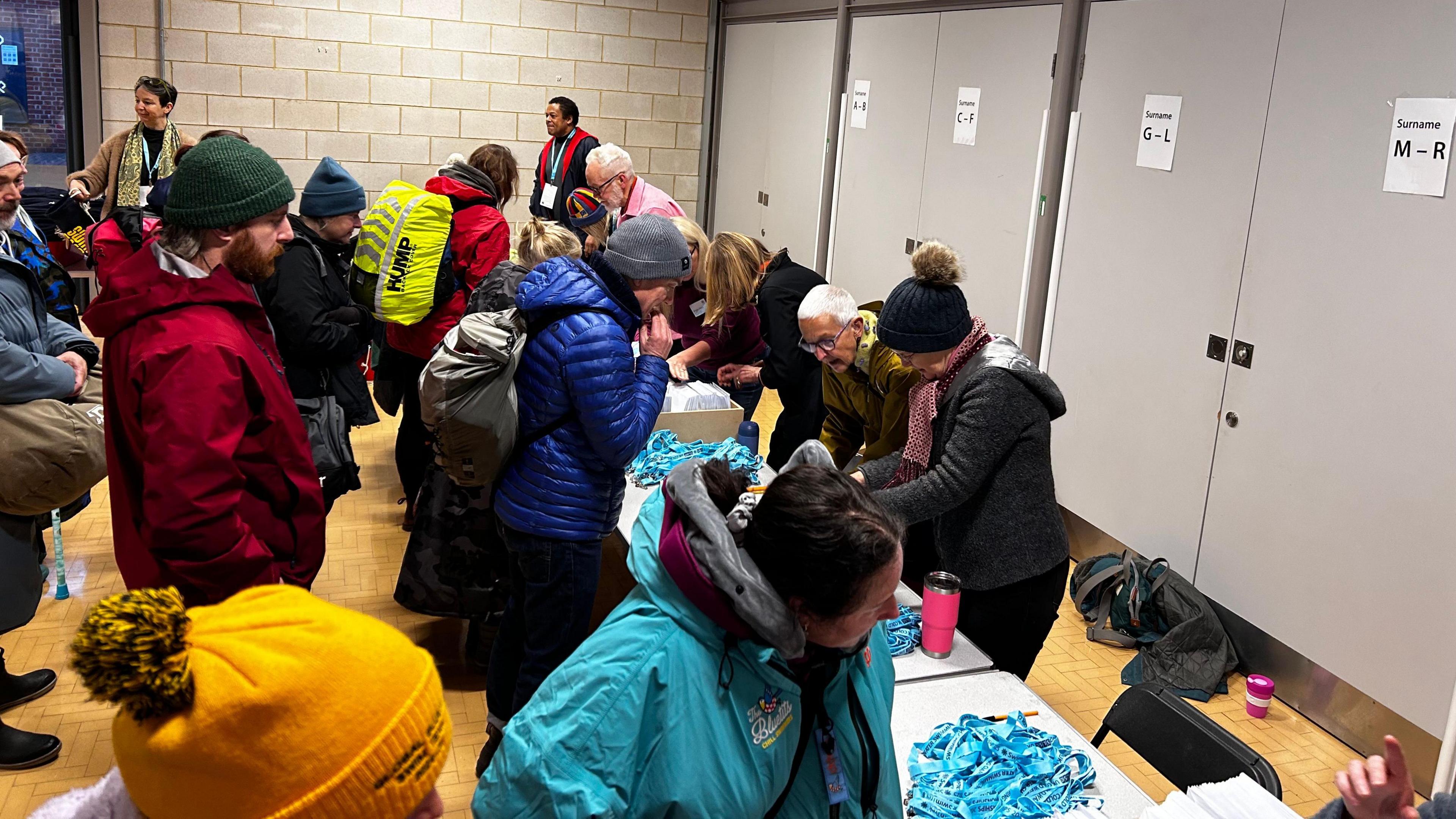 Three queues of people sign in for the swimming championships at Tooting Bec Lido.