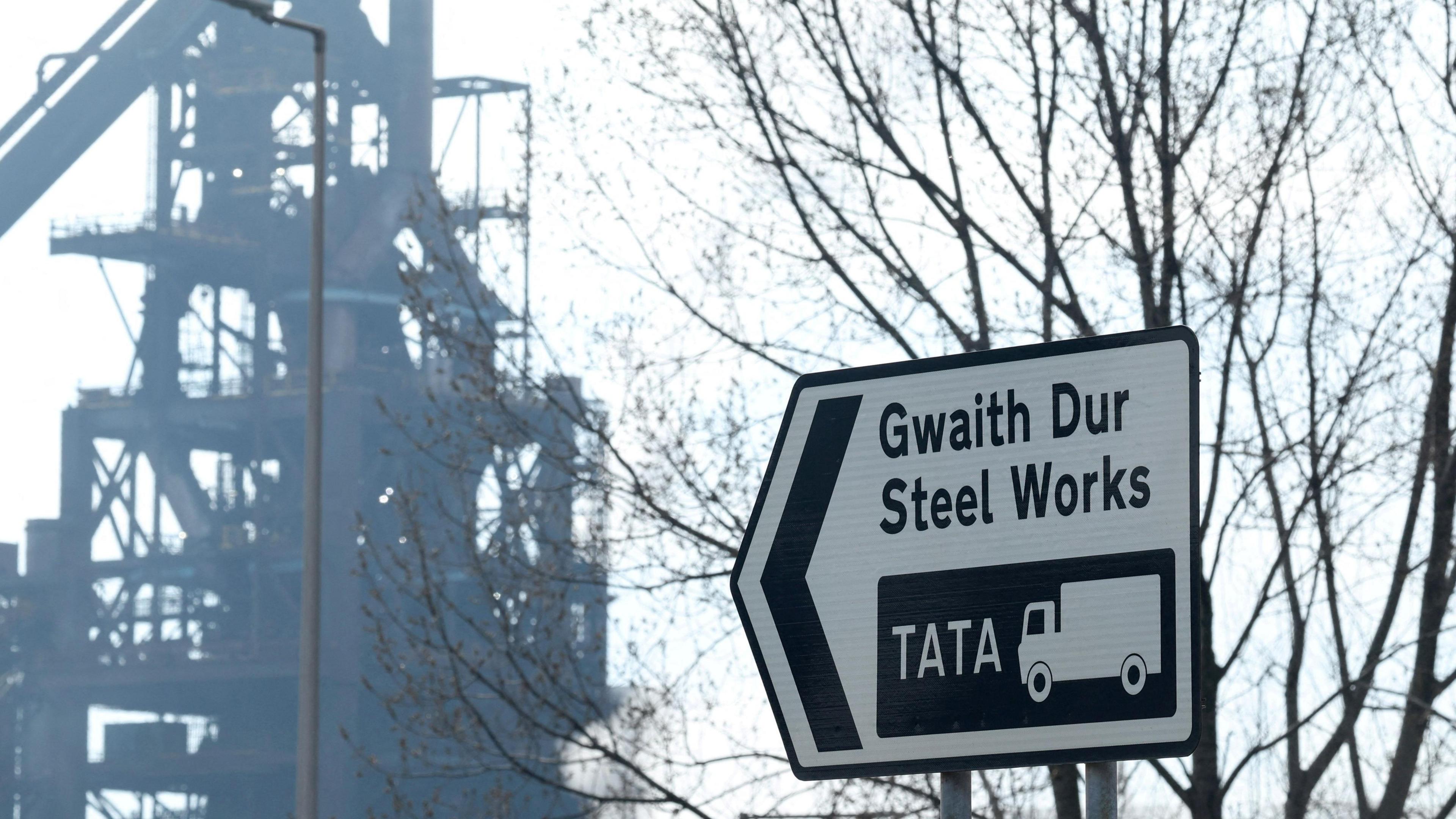 Arwydd ar y ffordd i'r gweithfeydd dur ym Mhort Talbot sy'n dangos y geiriau "Gwaith Dur Steel Works" ac enw'r cwmni Tata ynghyd a llun o lori. Yn y cefndir mae un o'r hen ffwrneisi chwyth.