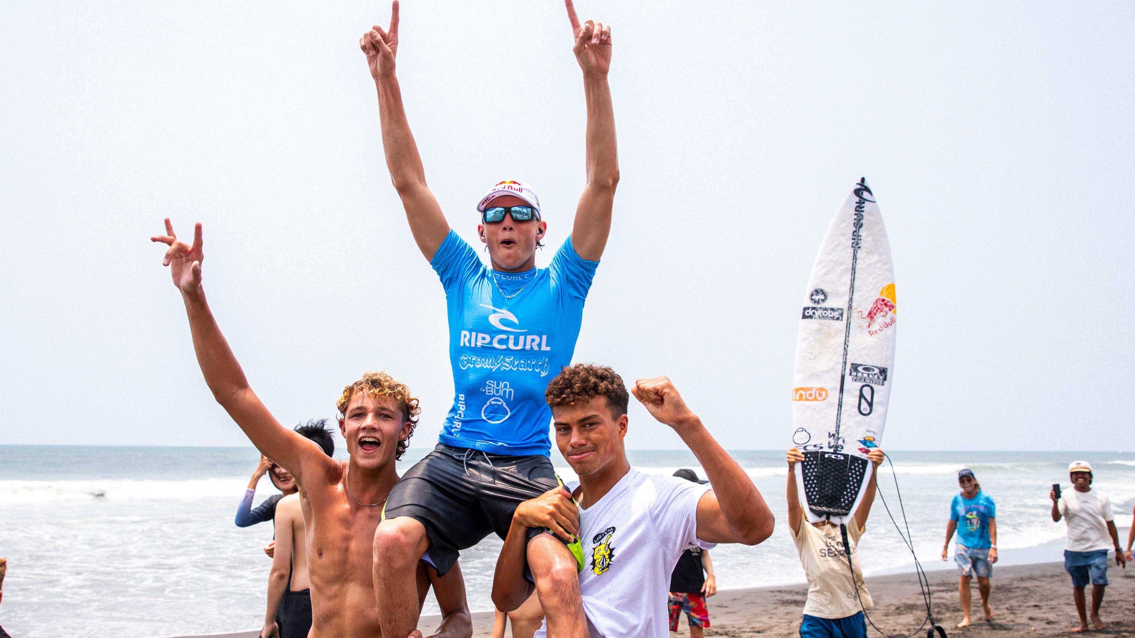 Lukas Skinner being hoisted onto the shoulders of two other surfers after winning an event