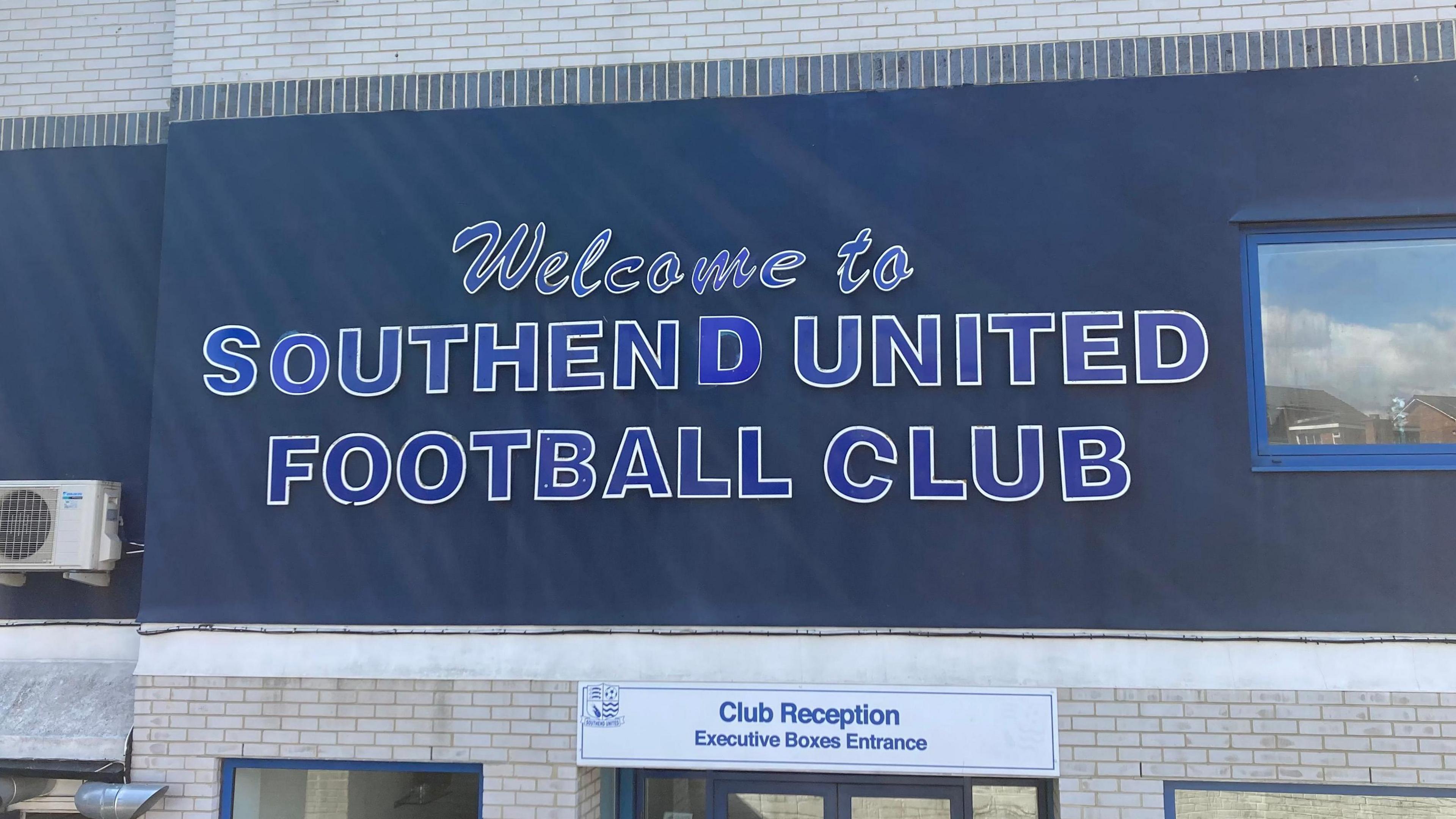 A sign at Roots Hall stadium on the stadium wall, reading WELCOME TO SOUTHEND UNITED FOOTBALL CLUB.