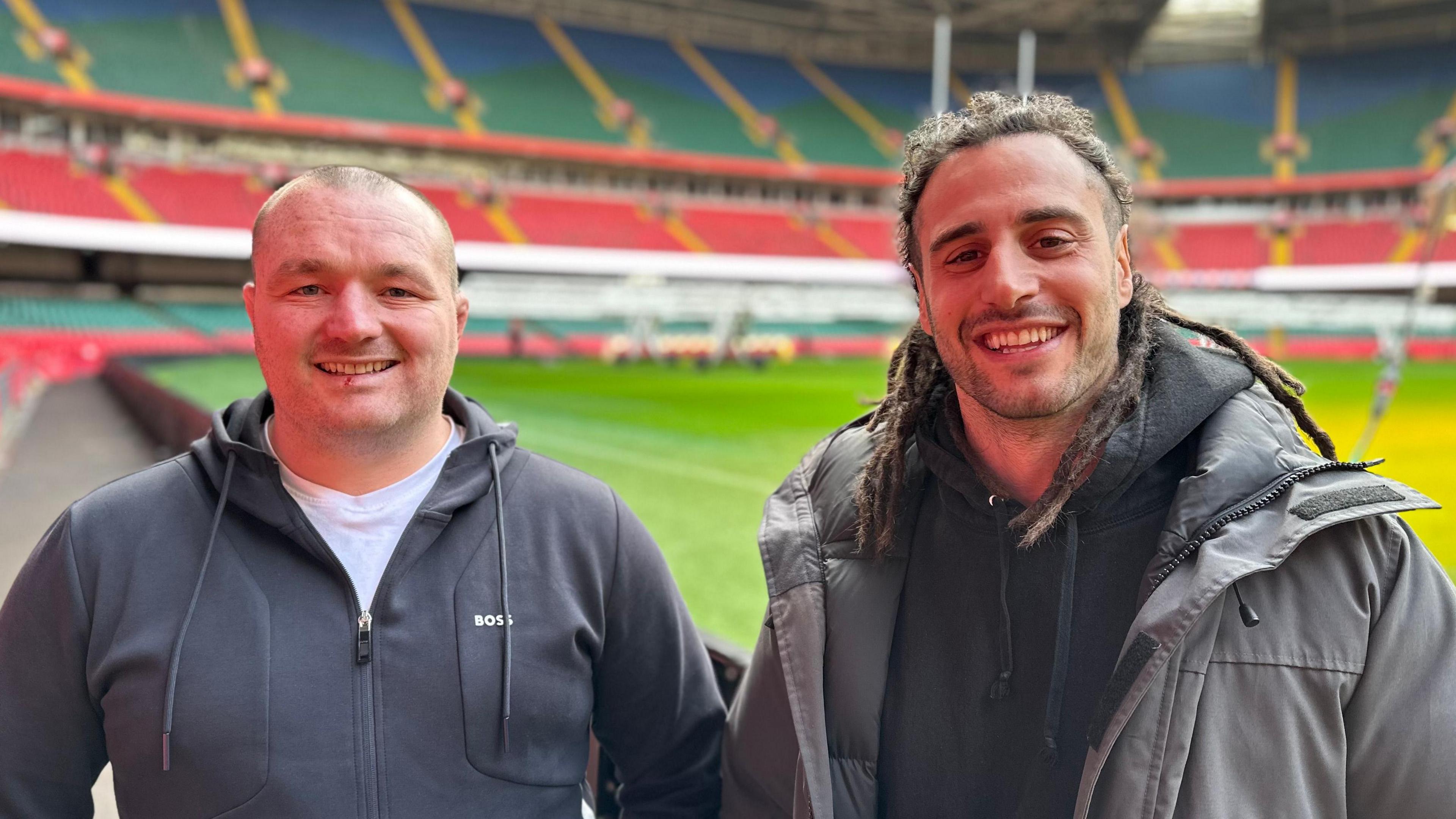 Ken Owens a Josh Navidi yn sefyll wrth ymyl y cae rygbi yn Stadiwm y Principality