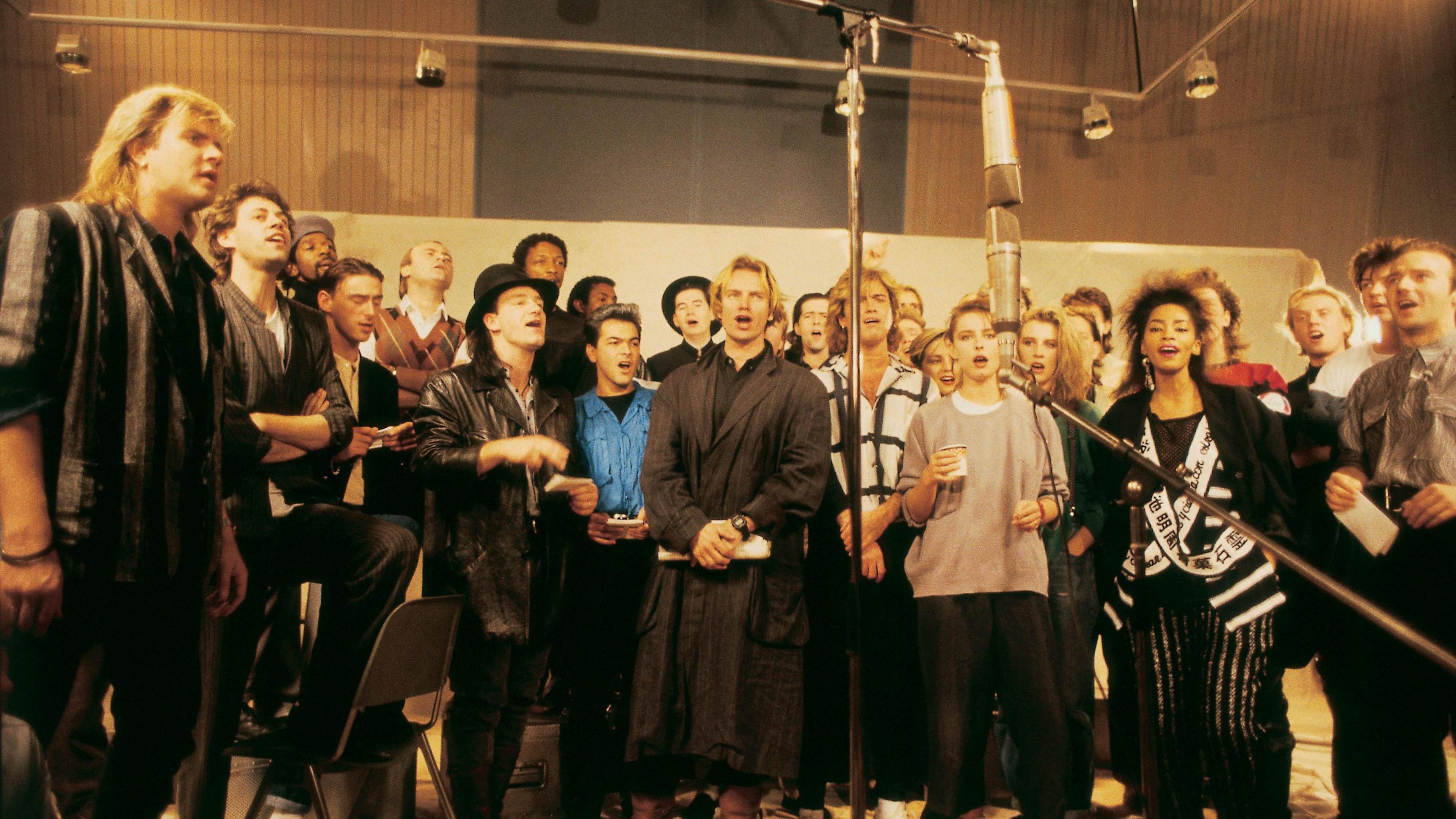 Sir Bob Geldof (second left), along with other artists recording the first ever Band Aid single, Do They Know It's Christmas. George Michael is in the middle.