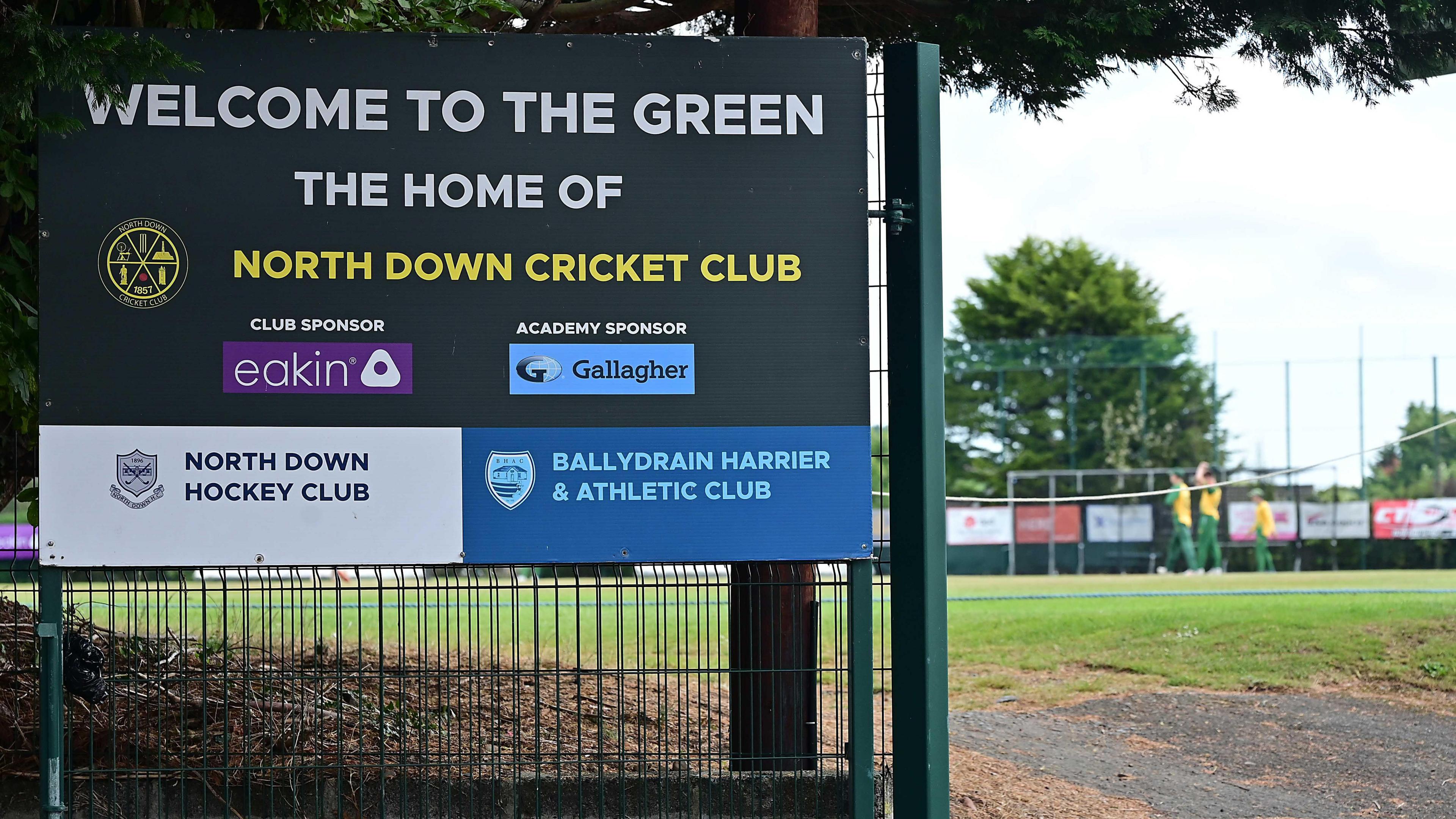 A large green sign outside the entrance to North Down Cricket Club. It reads: "Welcome to the Green, the home of North Down Cricket Club.'"