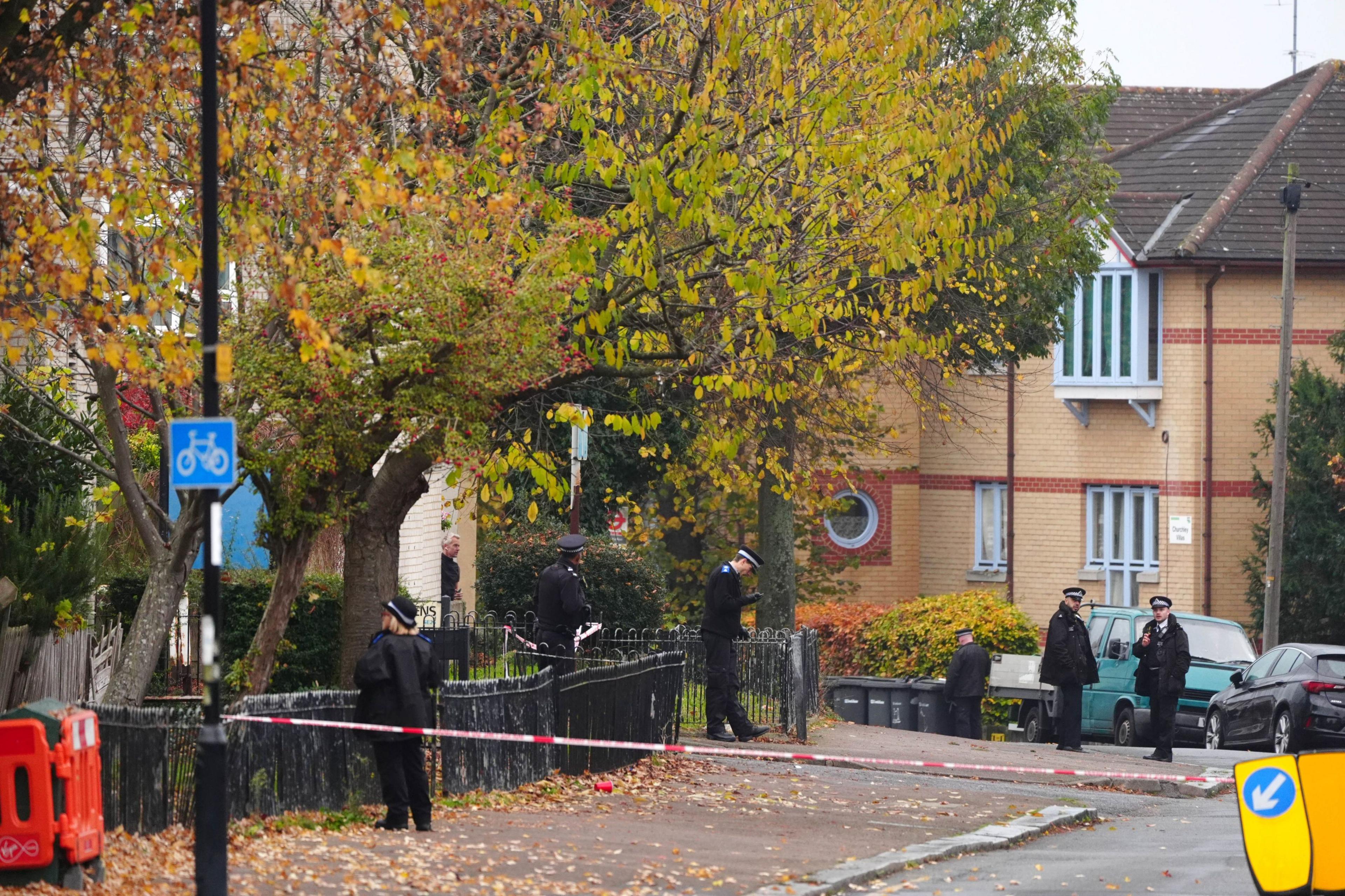 Part of a residential street - Wells Park Road - cordoned off, with several police officers present