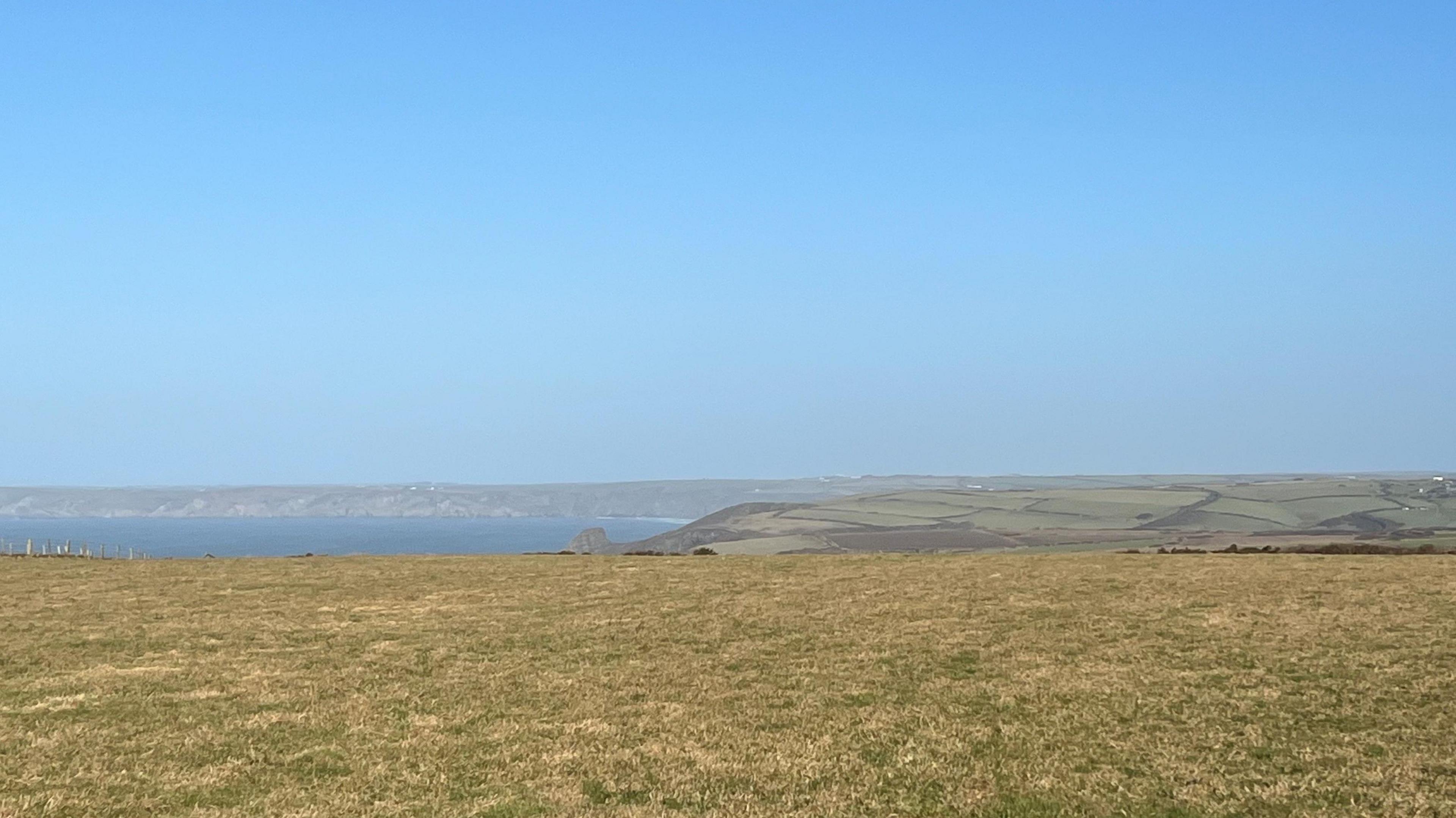 Location of Clifftops Camping at Druidston, showing a large field overlooking mountains and water.