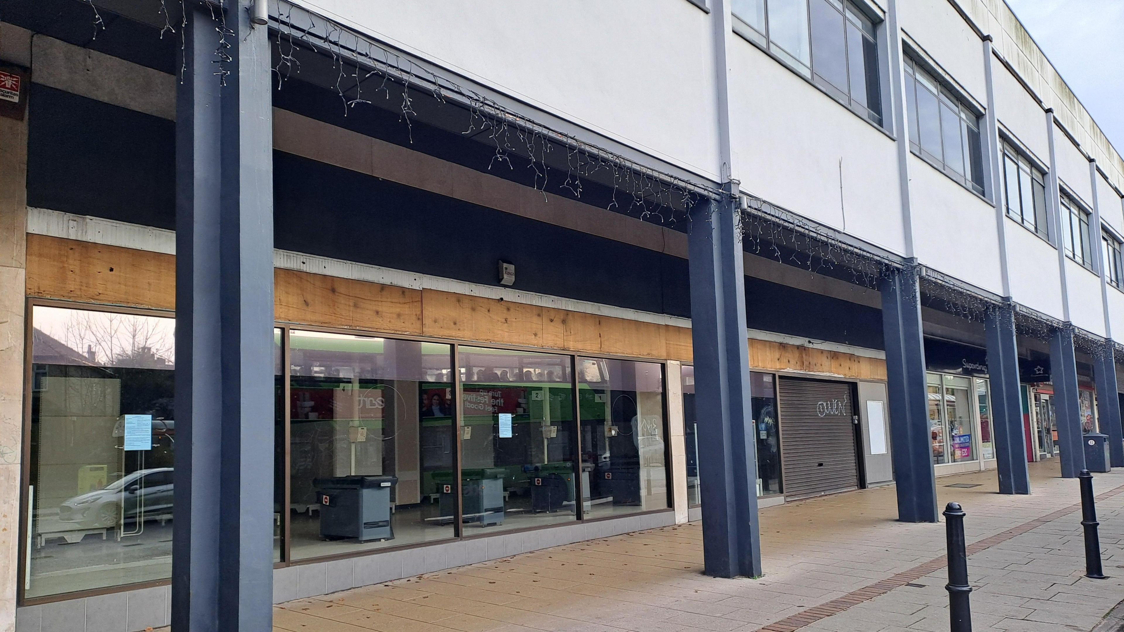 A vacant retail space along a main road.