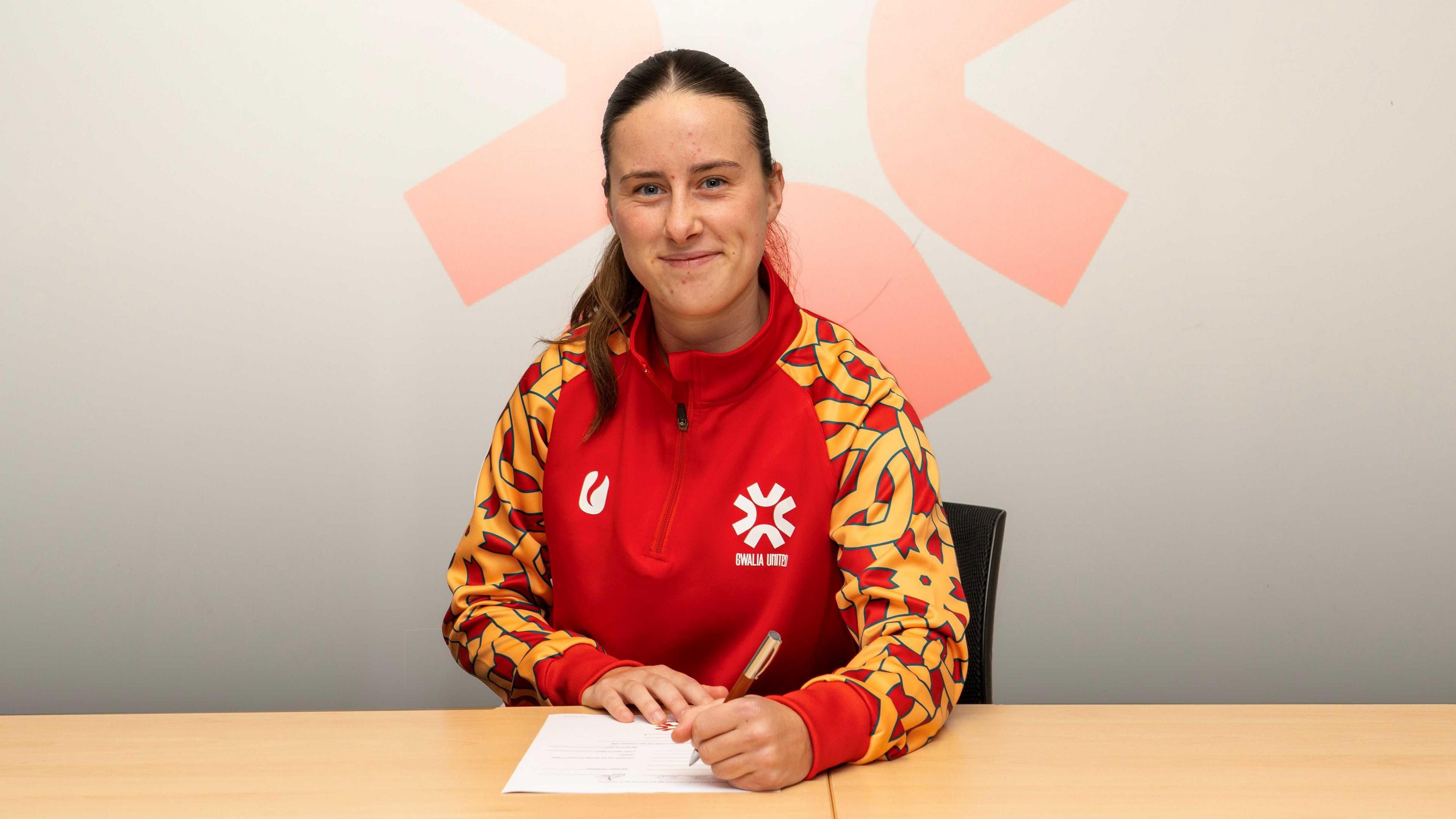 Anna Powell signing for Gwalia United 