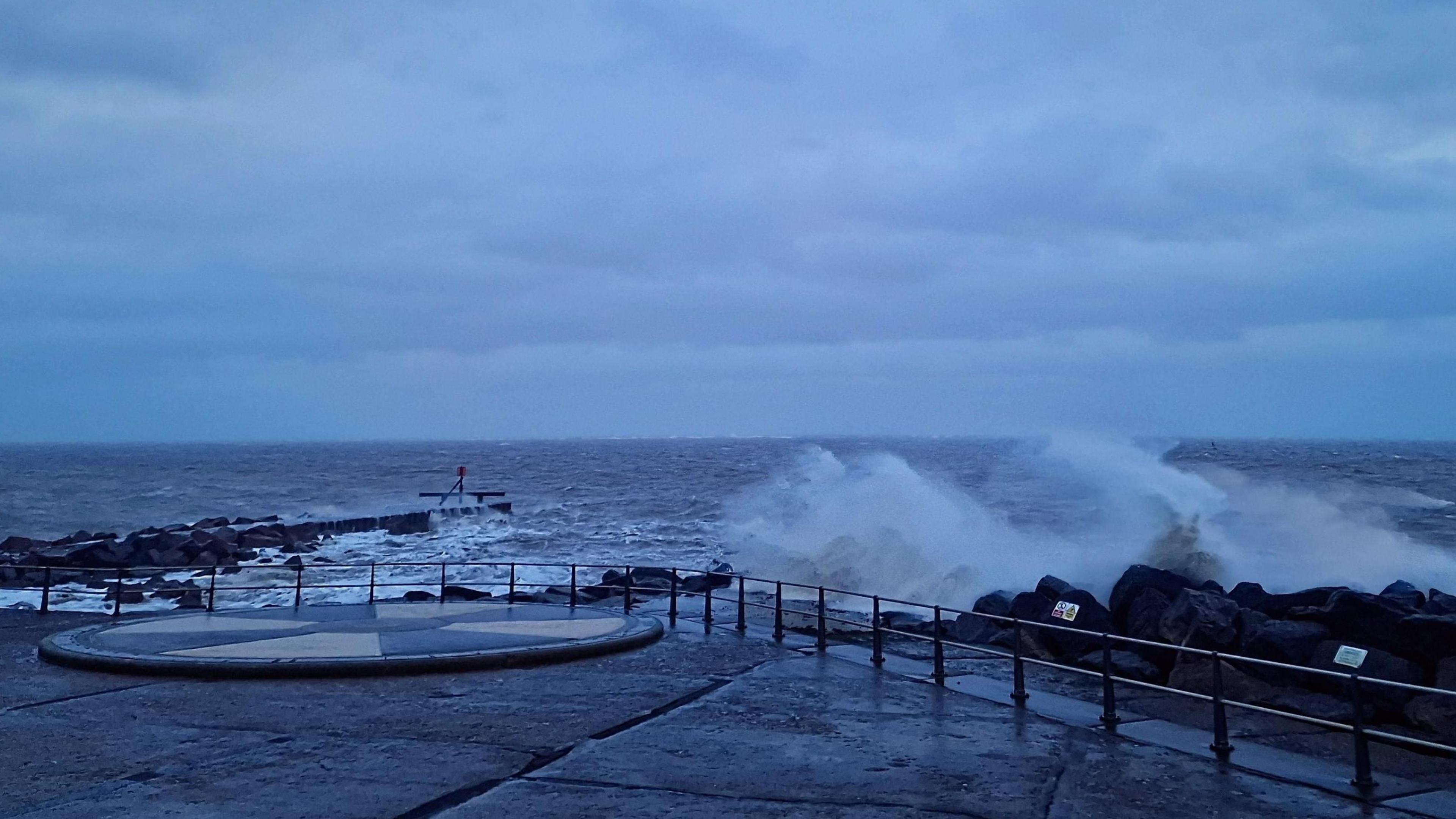 Lowestoft seafront, with waves crashing against rocks during Storm Bert