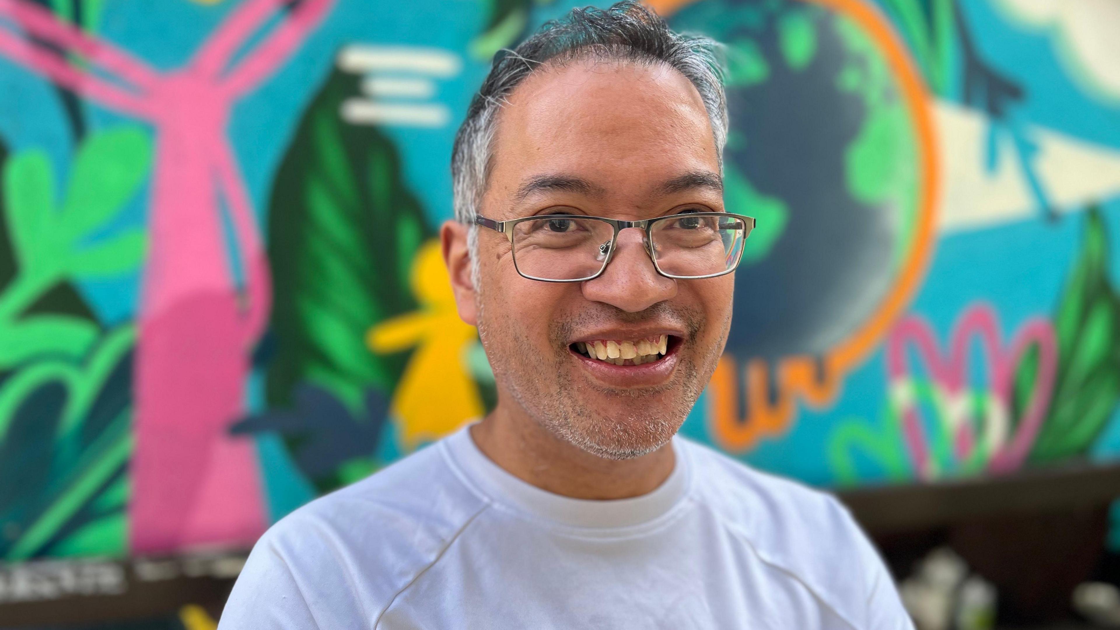 Andy in front of a colourful background