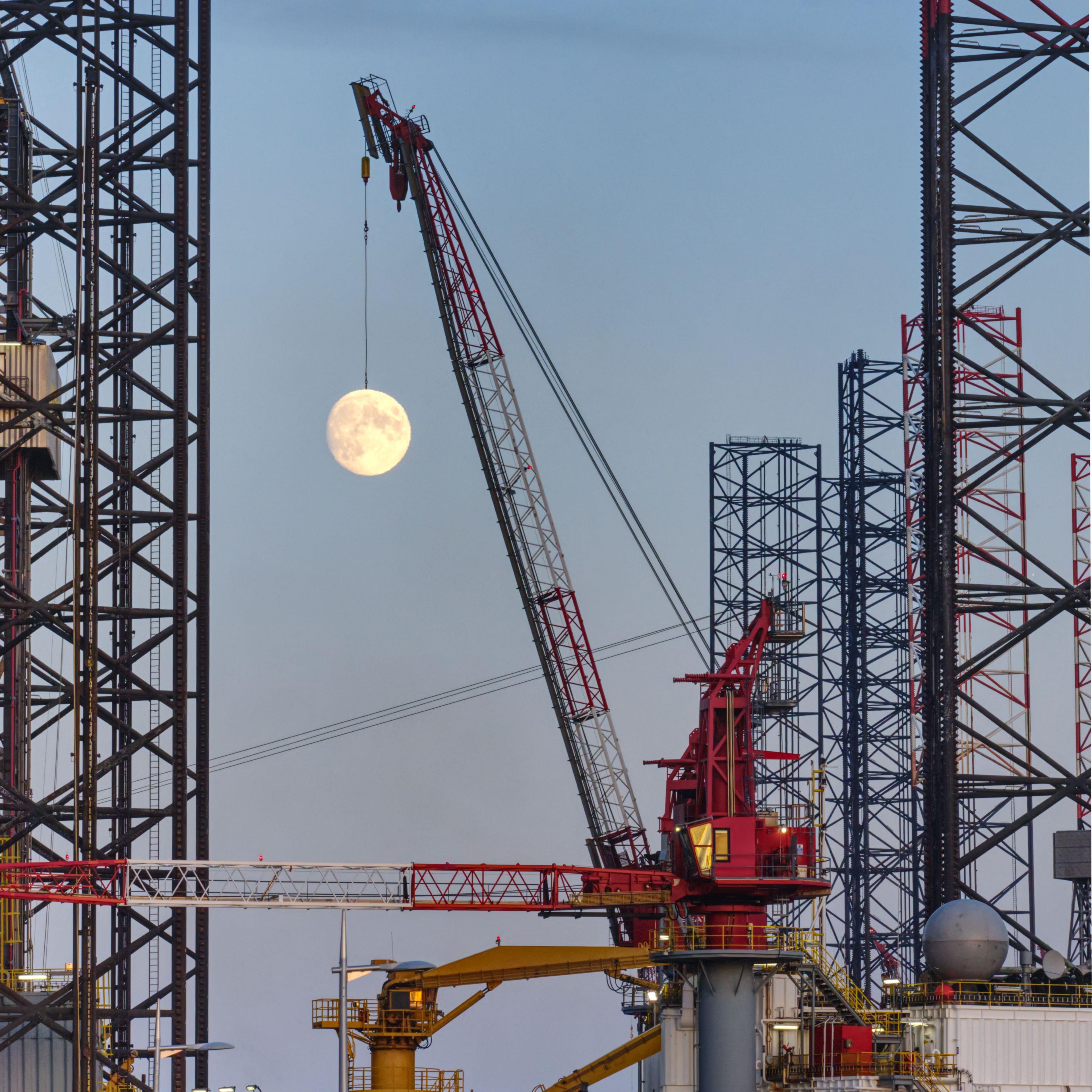 The moon positioned below a crane