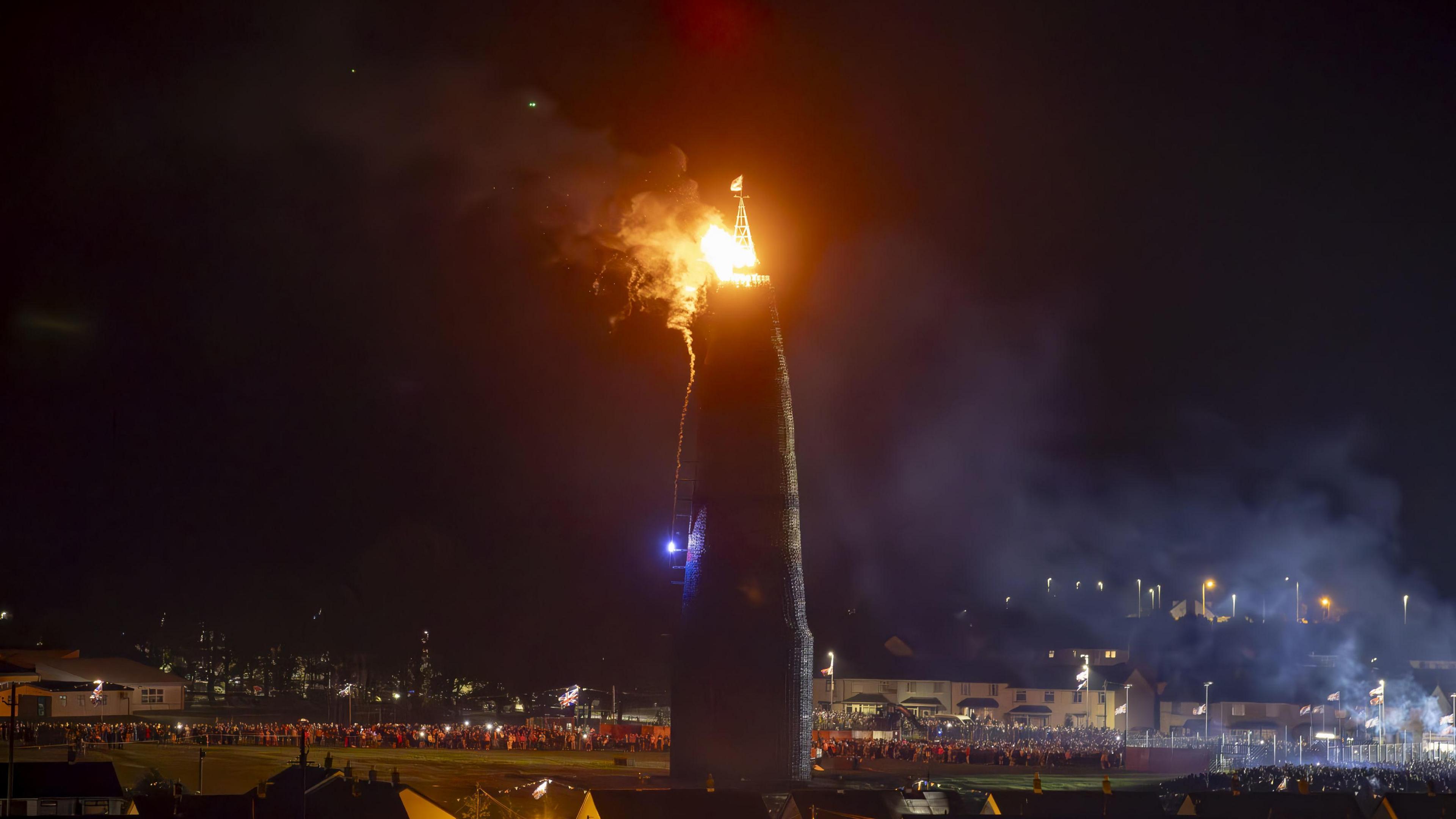 People watch the burning of the Craigyhill bonfire in Larne, Co Antrim, on the Eleventh night. ushering in the Twelfth commemorations. Picture date: Tuesday July 11, 2023.