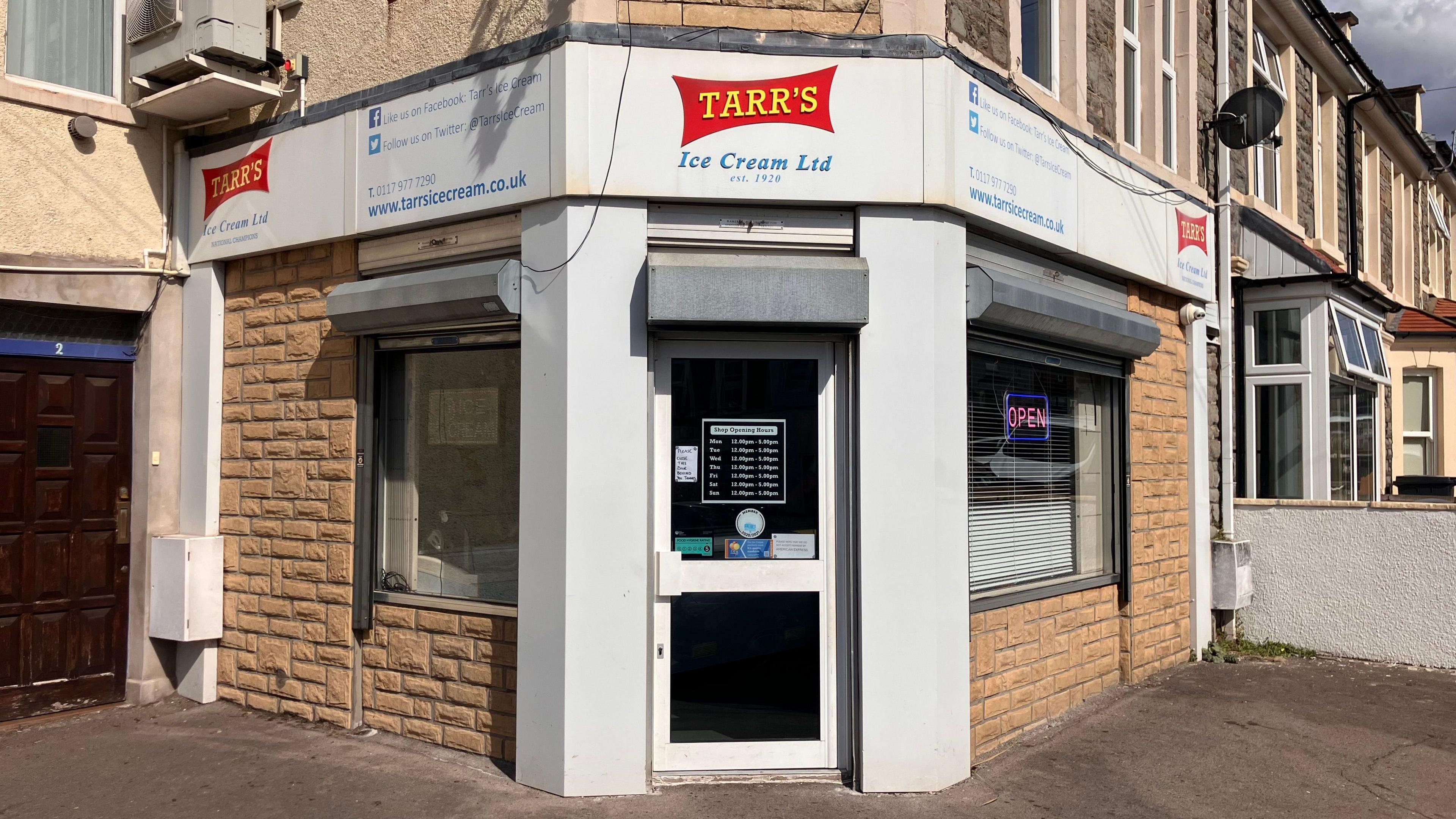 The front of the shop entrance. It has the Red and yellow branded sign above the door that says 'Tarr's'