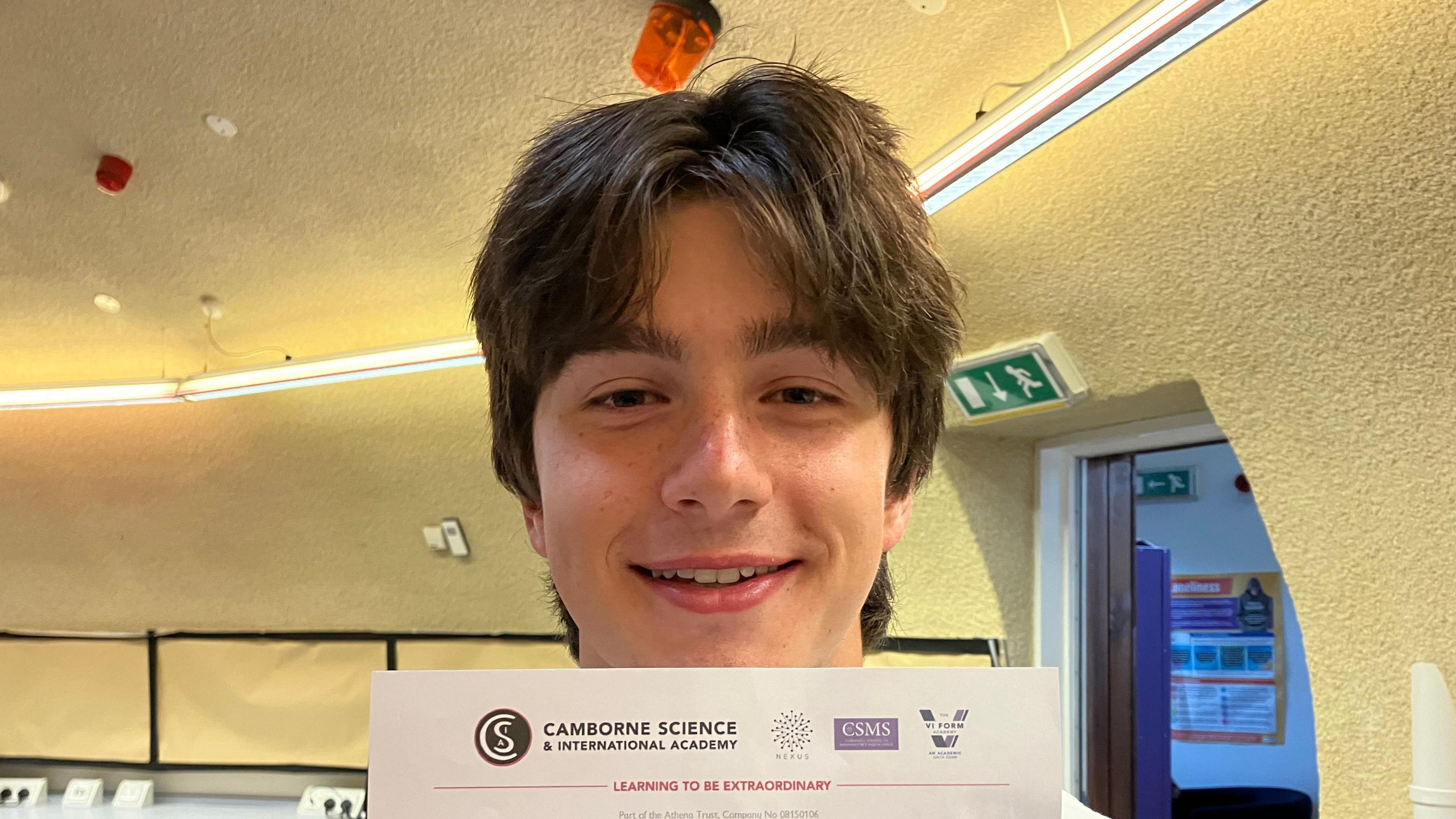 Sam Potter has brown hair and is smiling holding his results