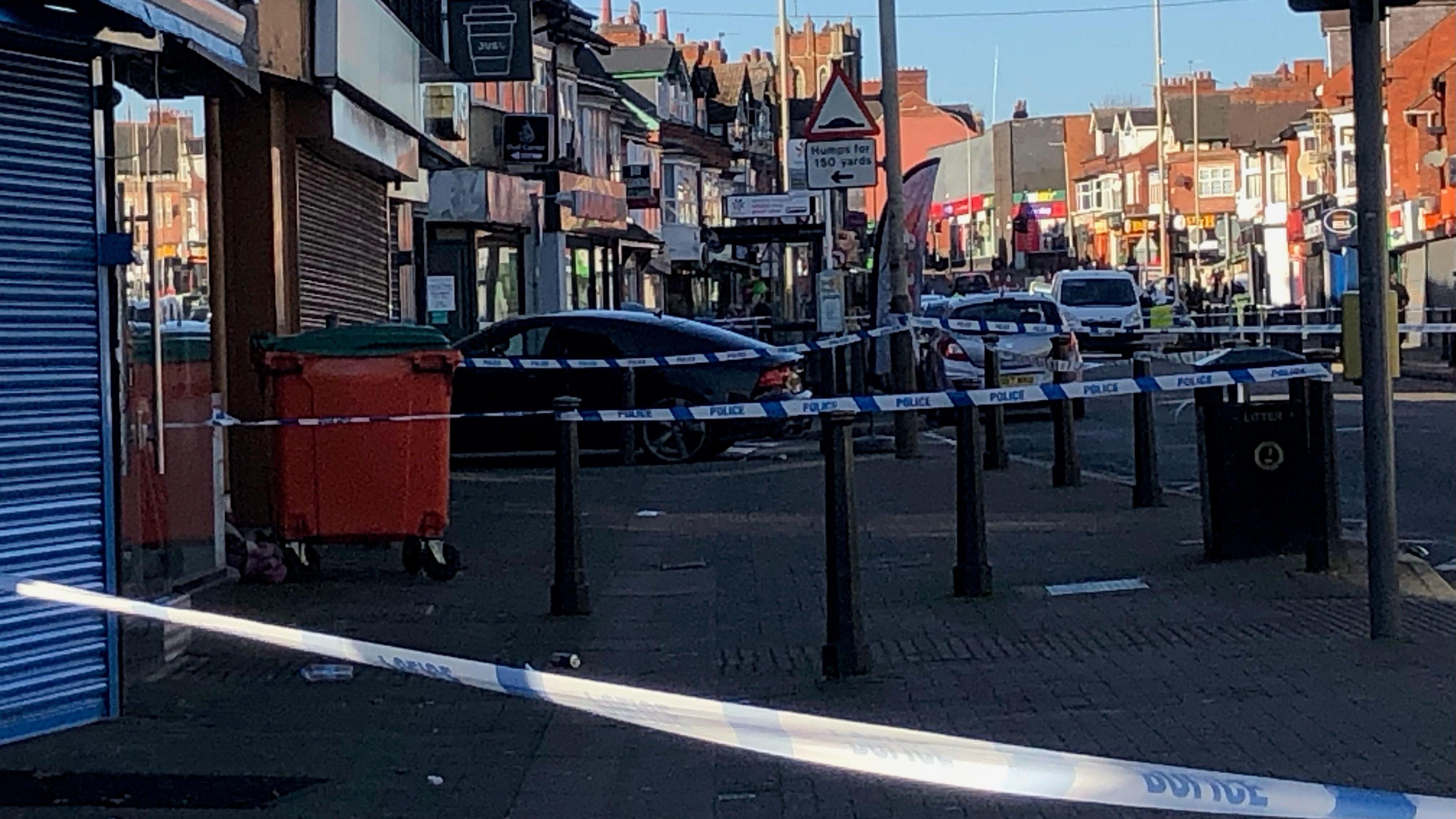 Police cordons across a large path following an incident on a pavement