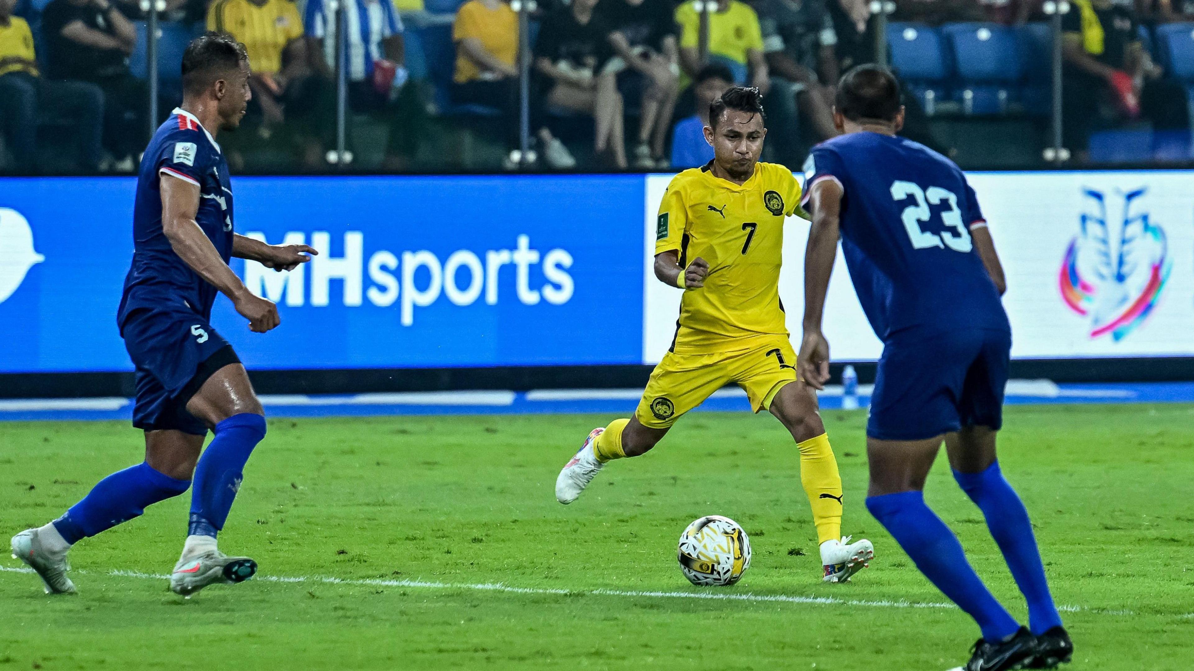 Malaysia national team player Faisal Halim, who was severely injured in an acid attack, dribbles past Nepal players during the Asian Cup qualifiers.
