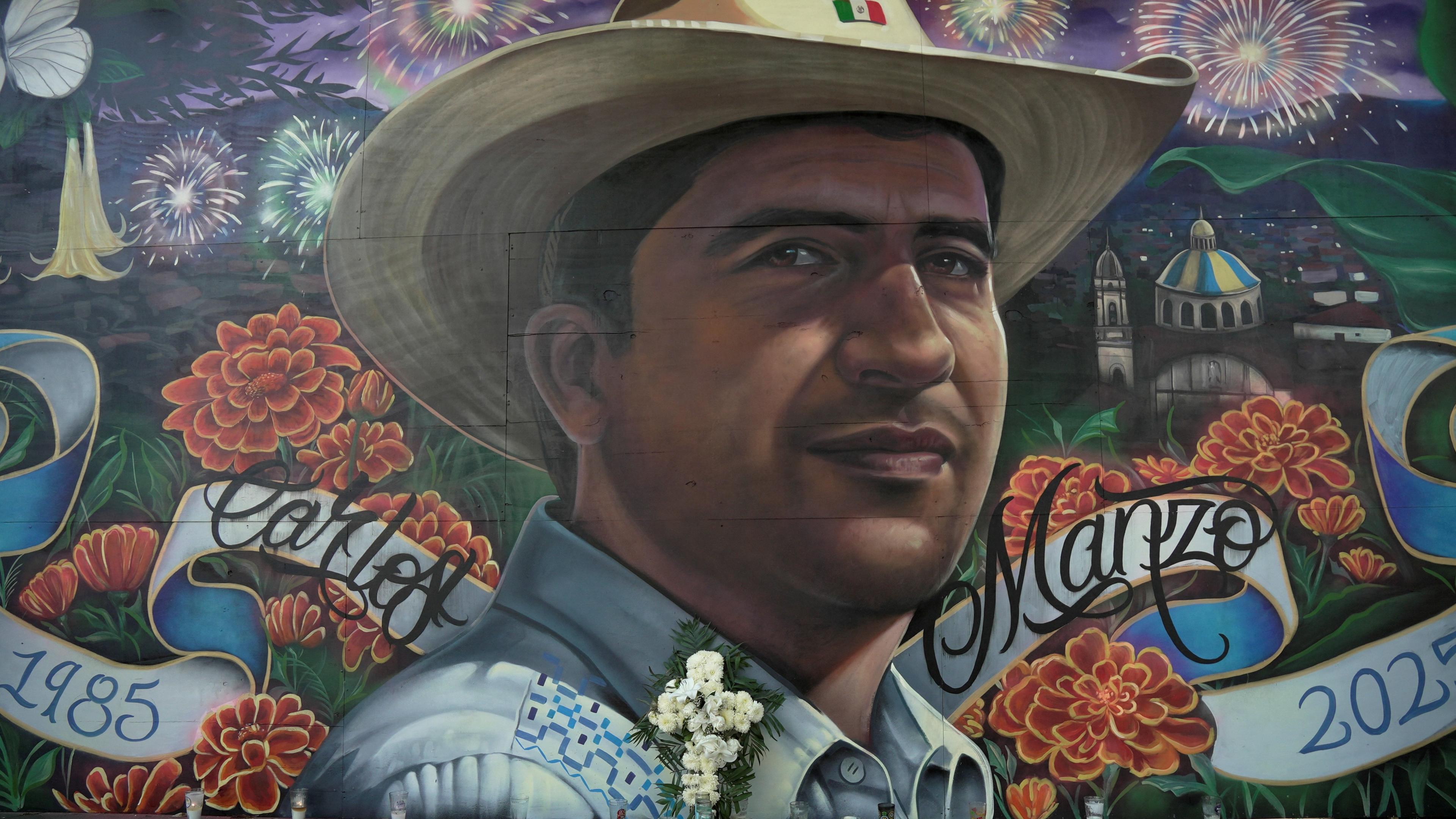 Flowers are left by a mural of the late Uruapan mayor Carlos Manzo