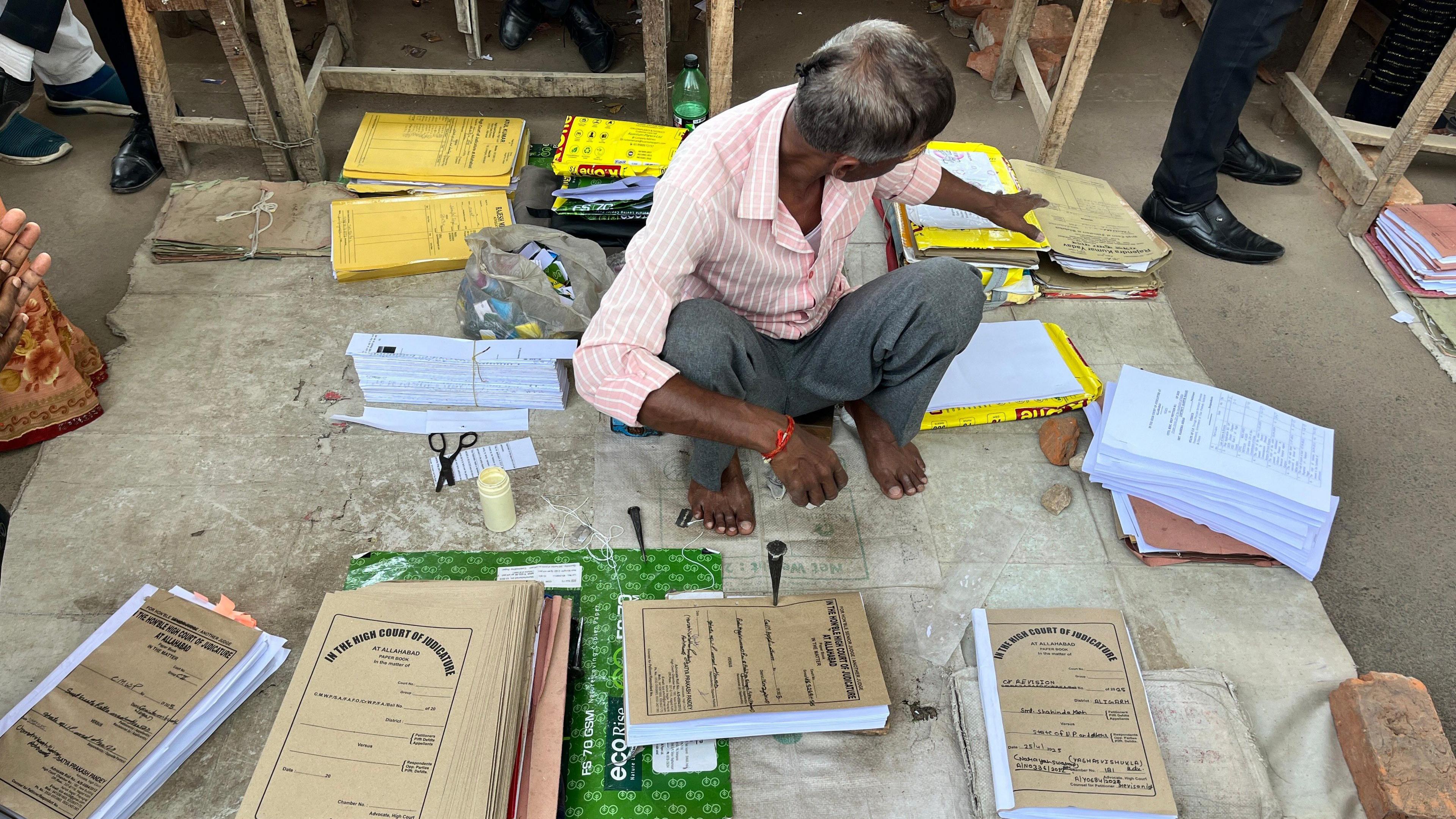 A man binds case files outside the Allahabad high court