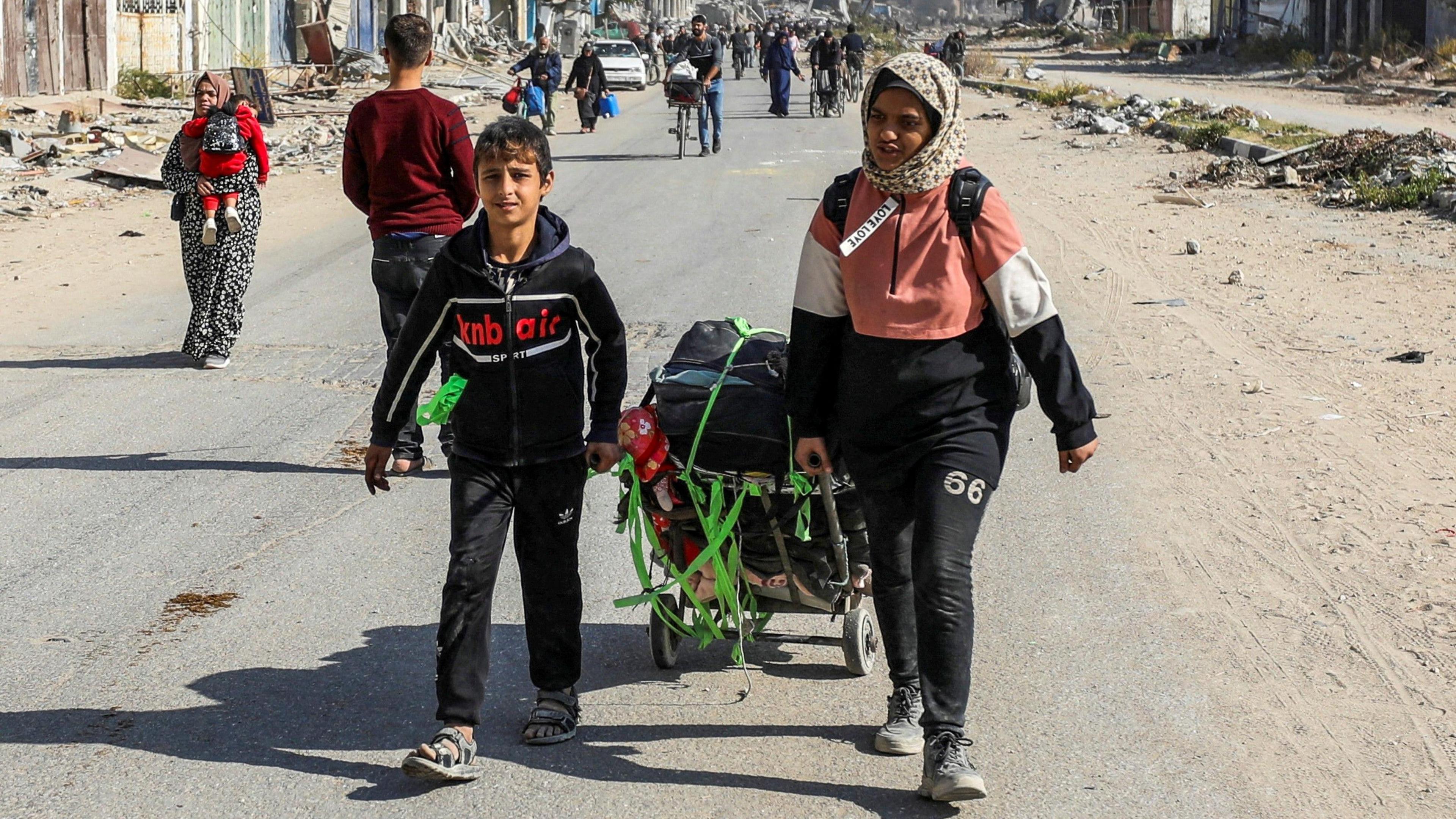 Two Palestinians are pulling carts through a wrecked part of the northern part of Gaza in Gaza City, 