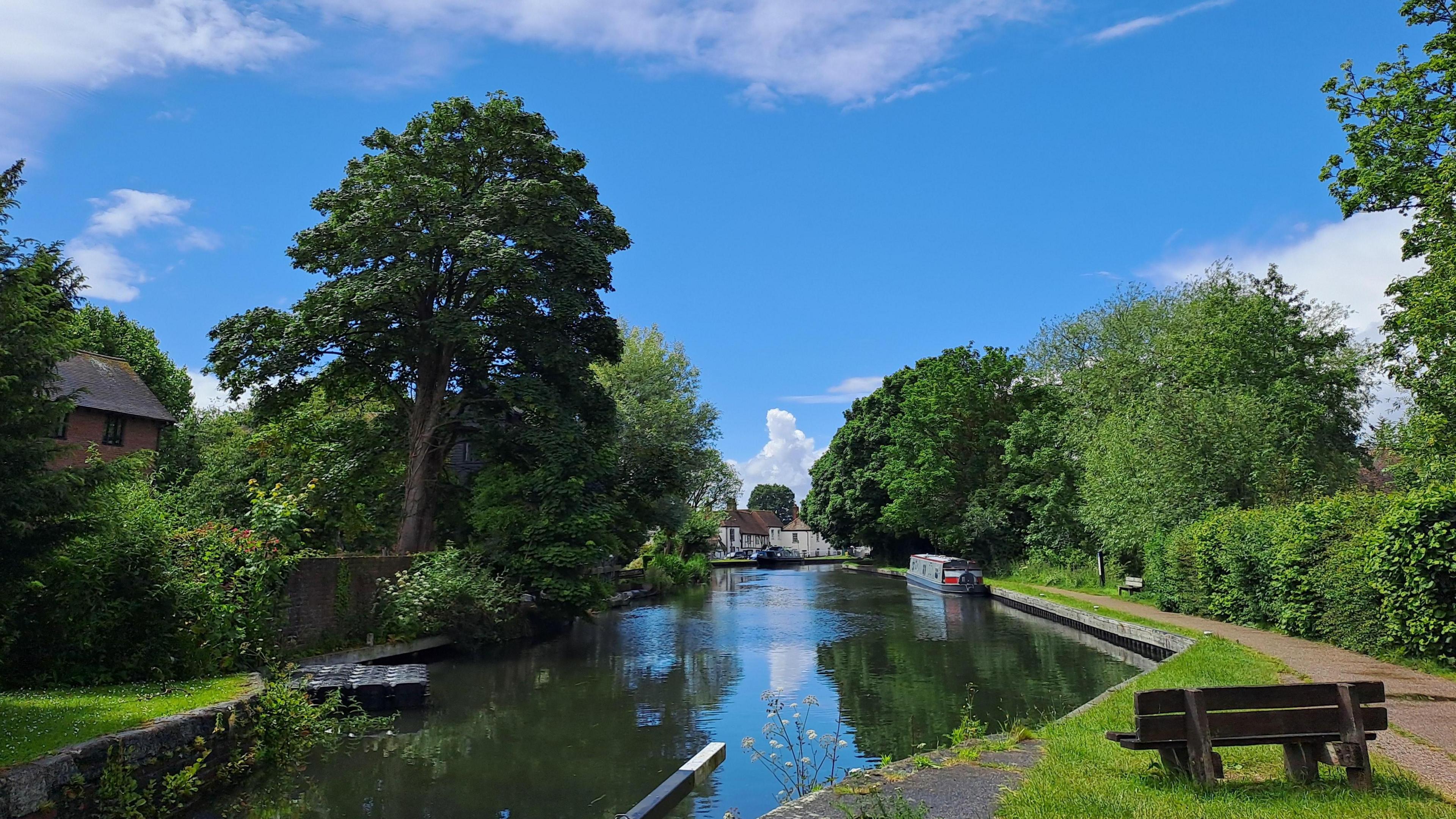 TUESDAY - A canal at Newbury with blue skies and a boat on the water