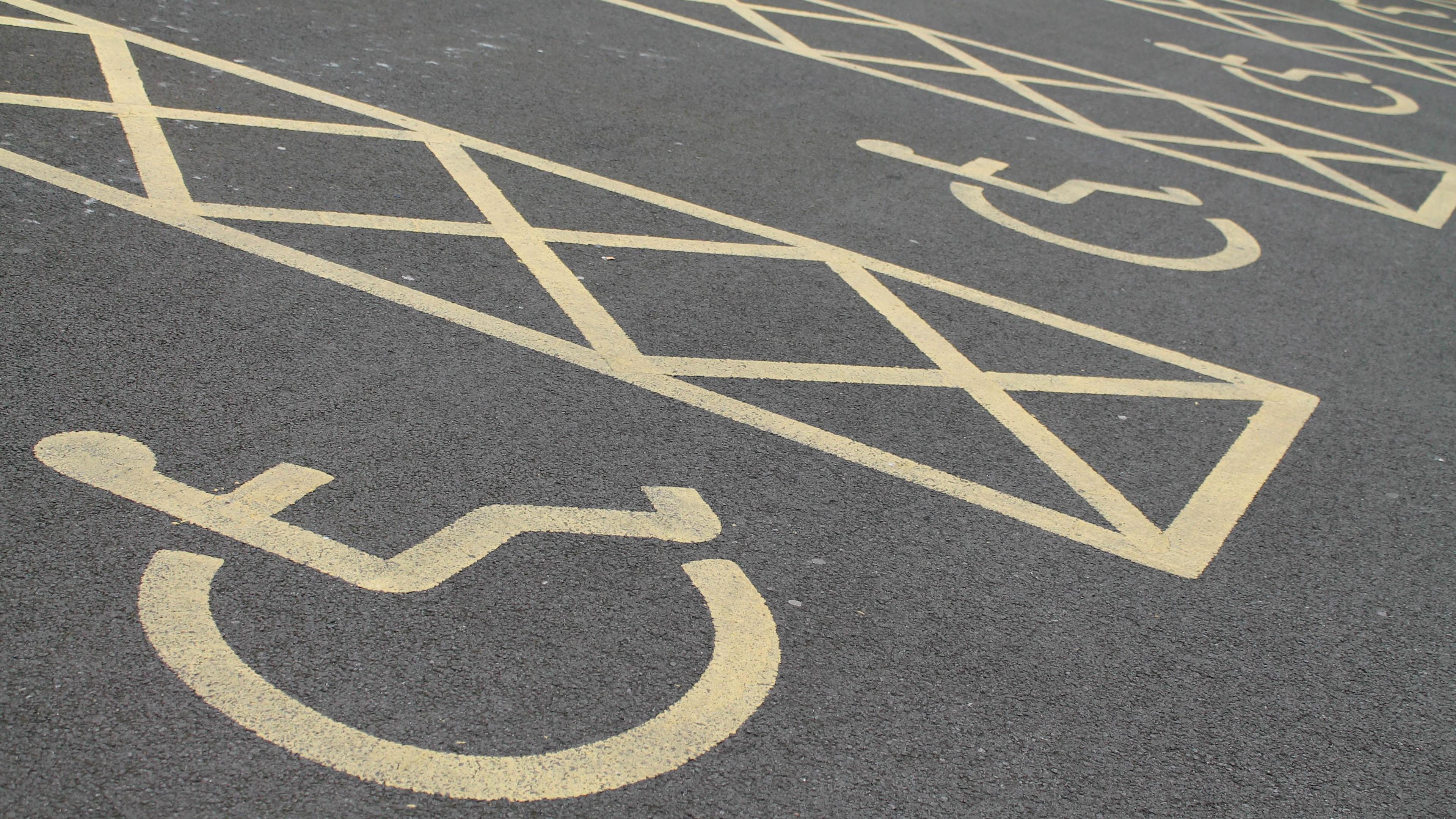 A row of disabled parking spaces. The markings are yellow. 