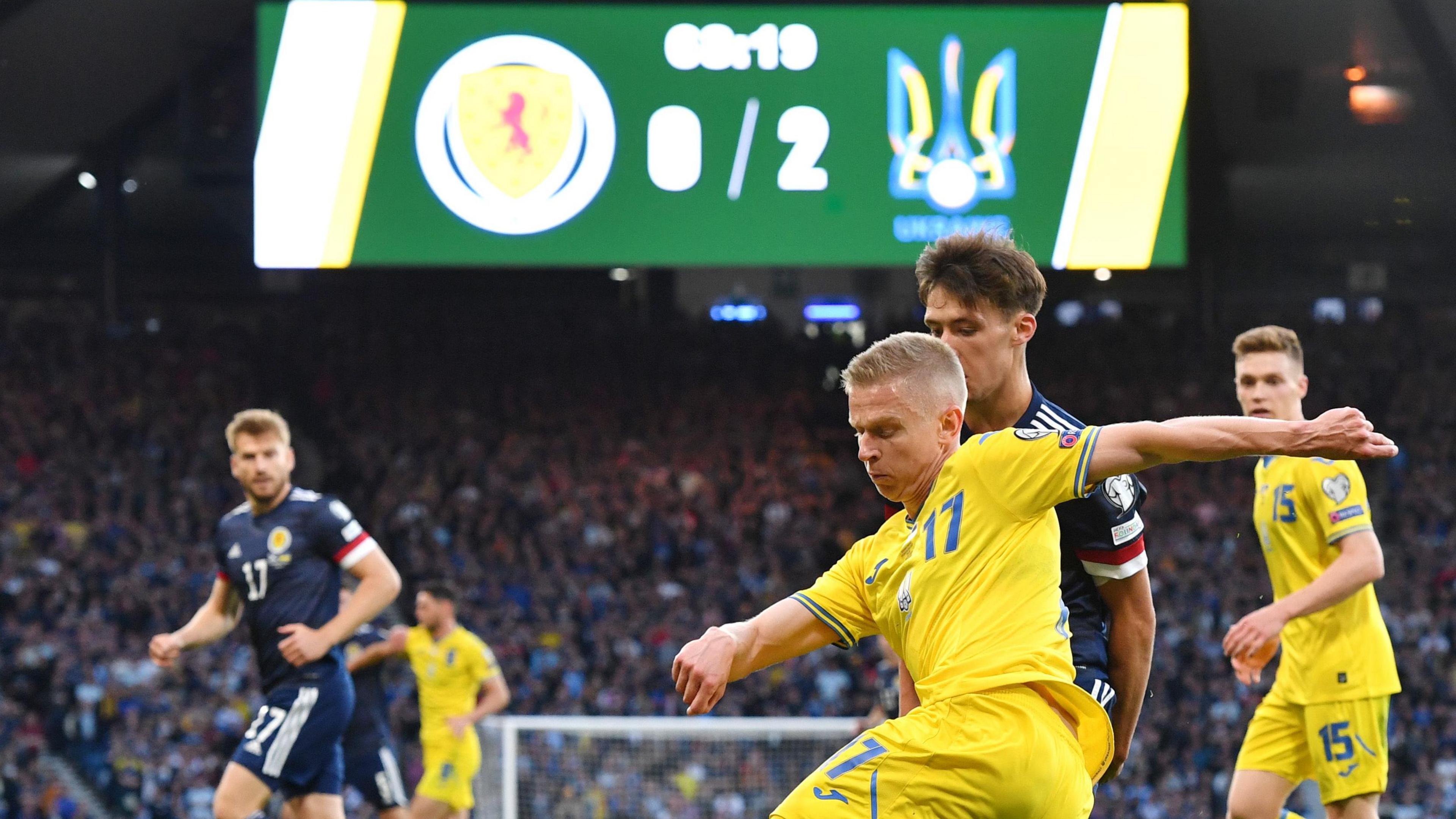 Oleksandr Zinchenko of Ukraine is challenged by Aaron Hickey of Scotland