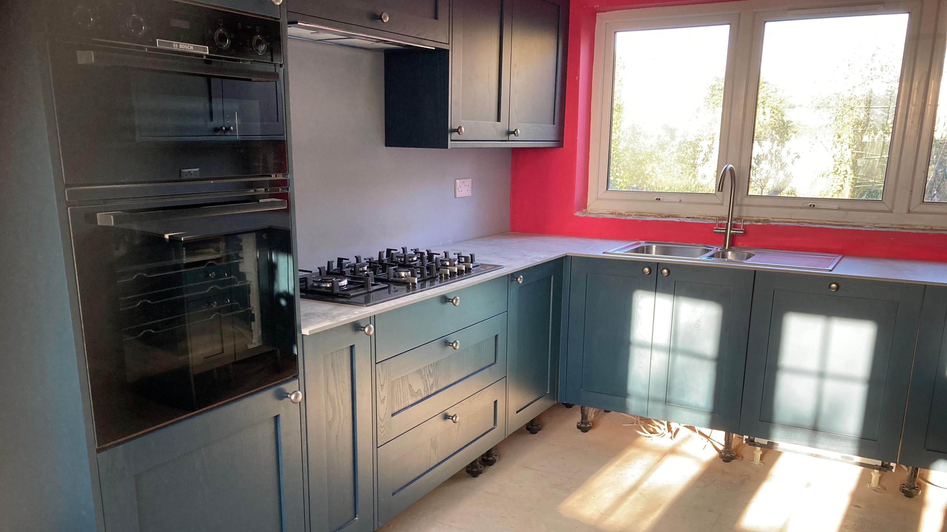 The picture shows a new blue kitchen has been fitted into the flood-damaged home and repair work is due to be completed soon