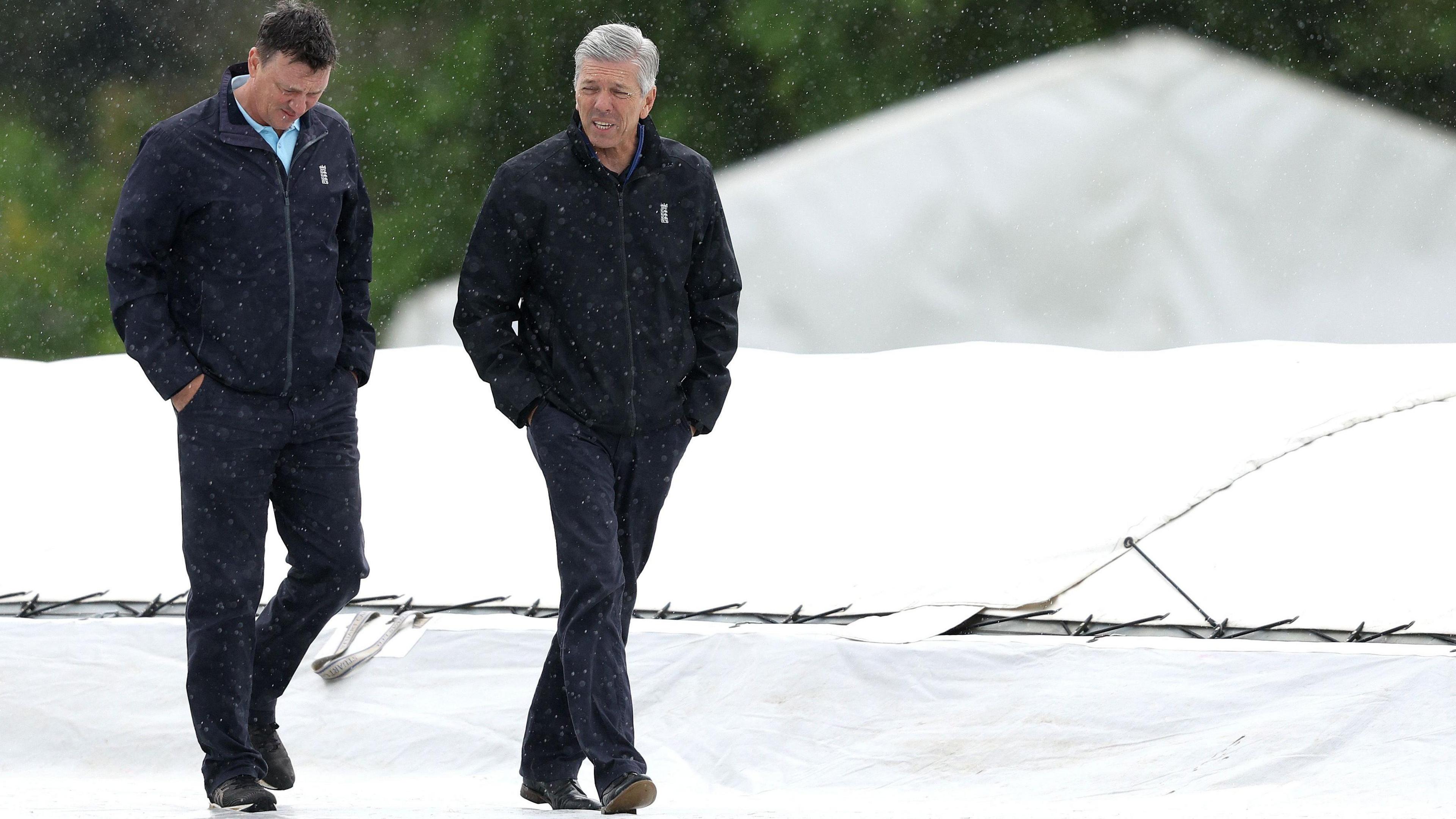 Umpires make a forlorn inspection of the pitch at Radlett