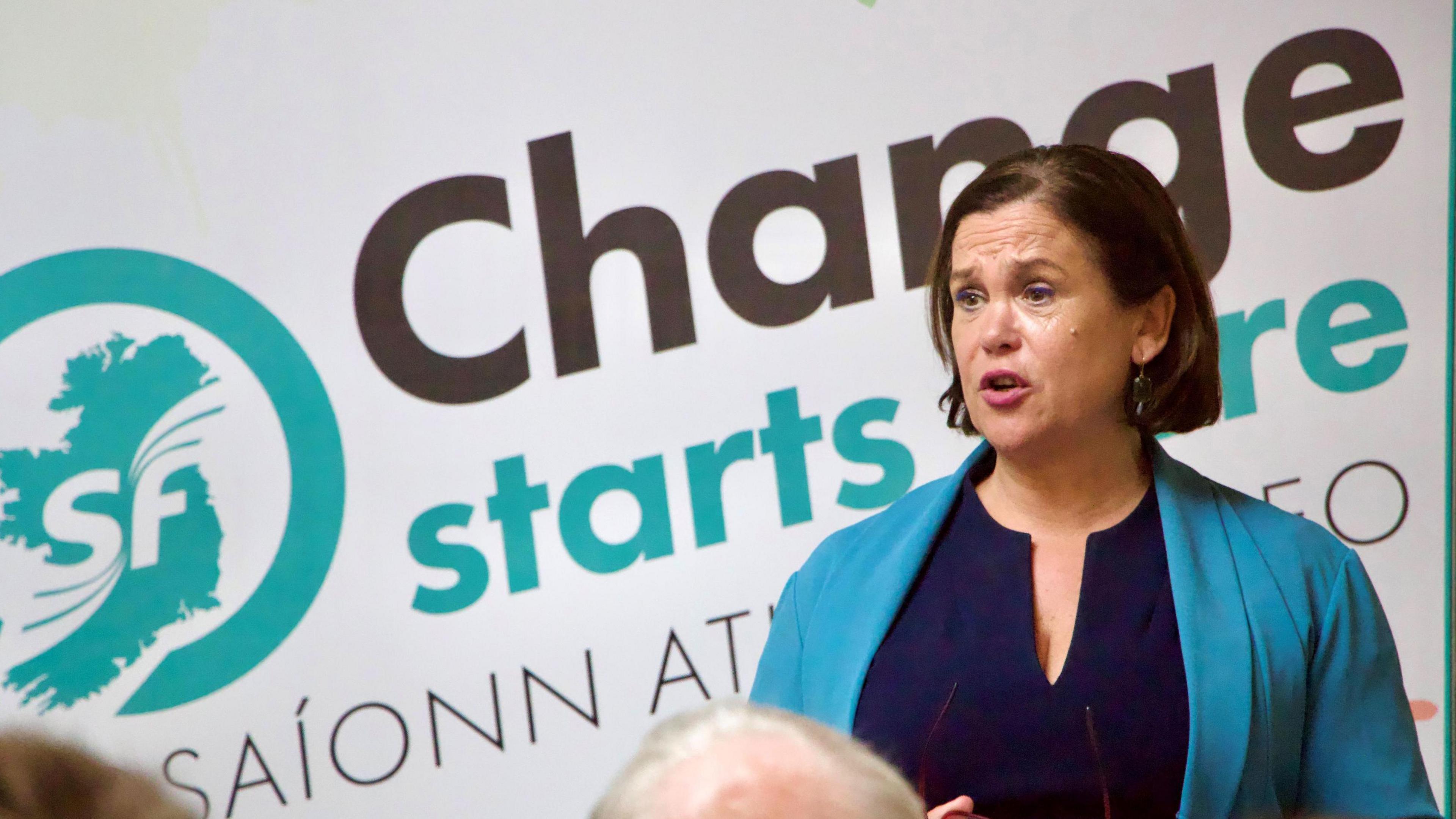 Mary Lou McDonald in front of "Change Starts Here" banner