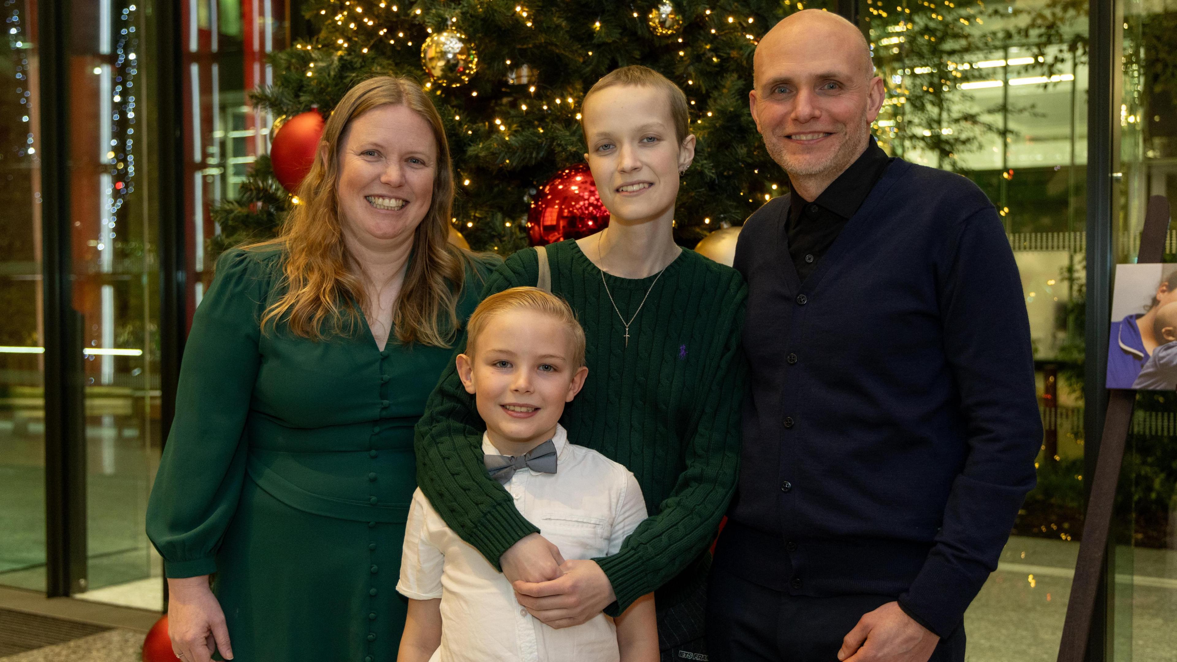 Liz Hatton with her mother, father and younger brother Mateo at an event in November 2024. Behind them is a Christmas tree with red and gold baubles. 