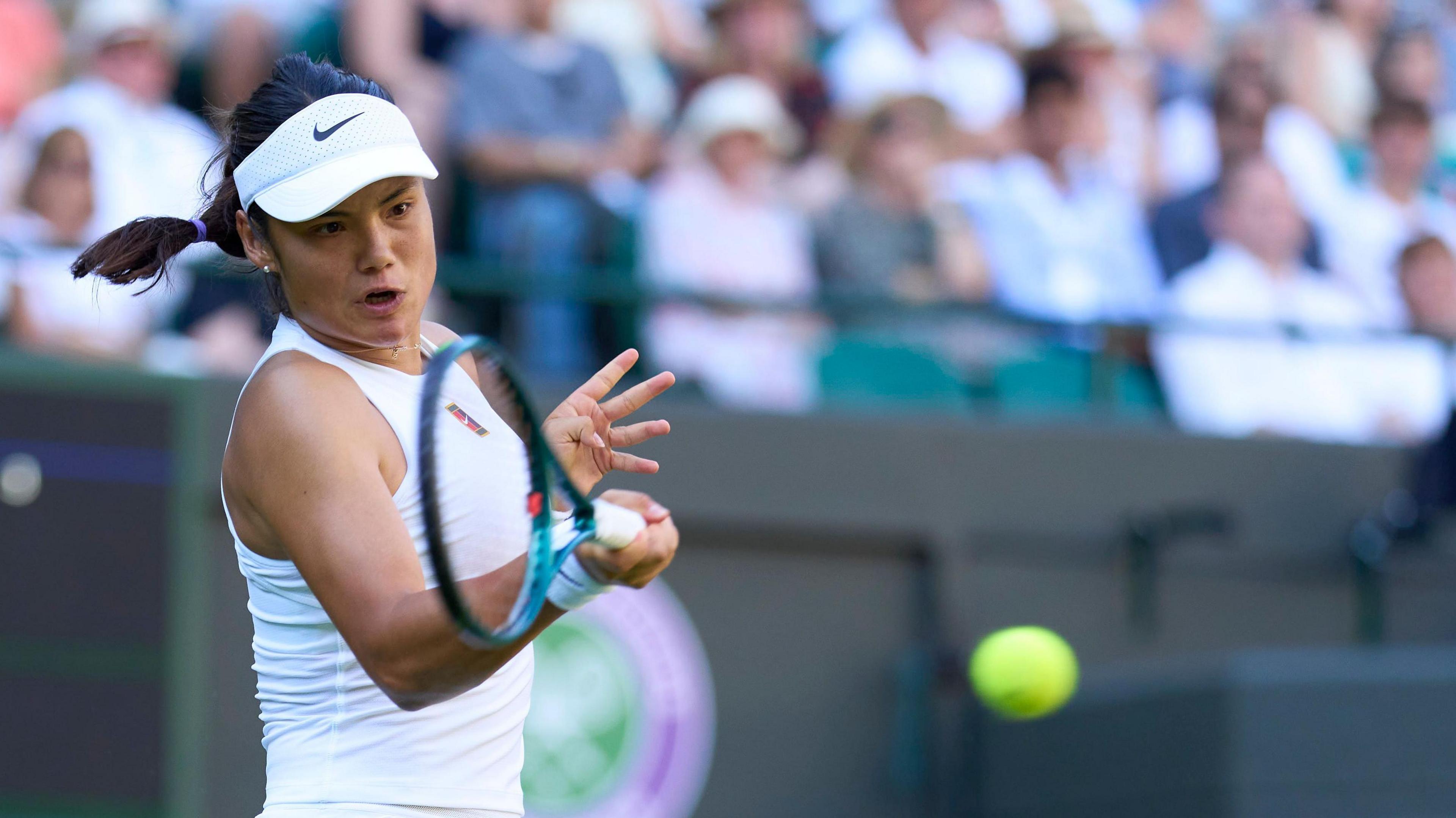 Emma Raducanu hits a return against Mimi Xu in the 2025 Wimbledon first round