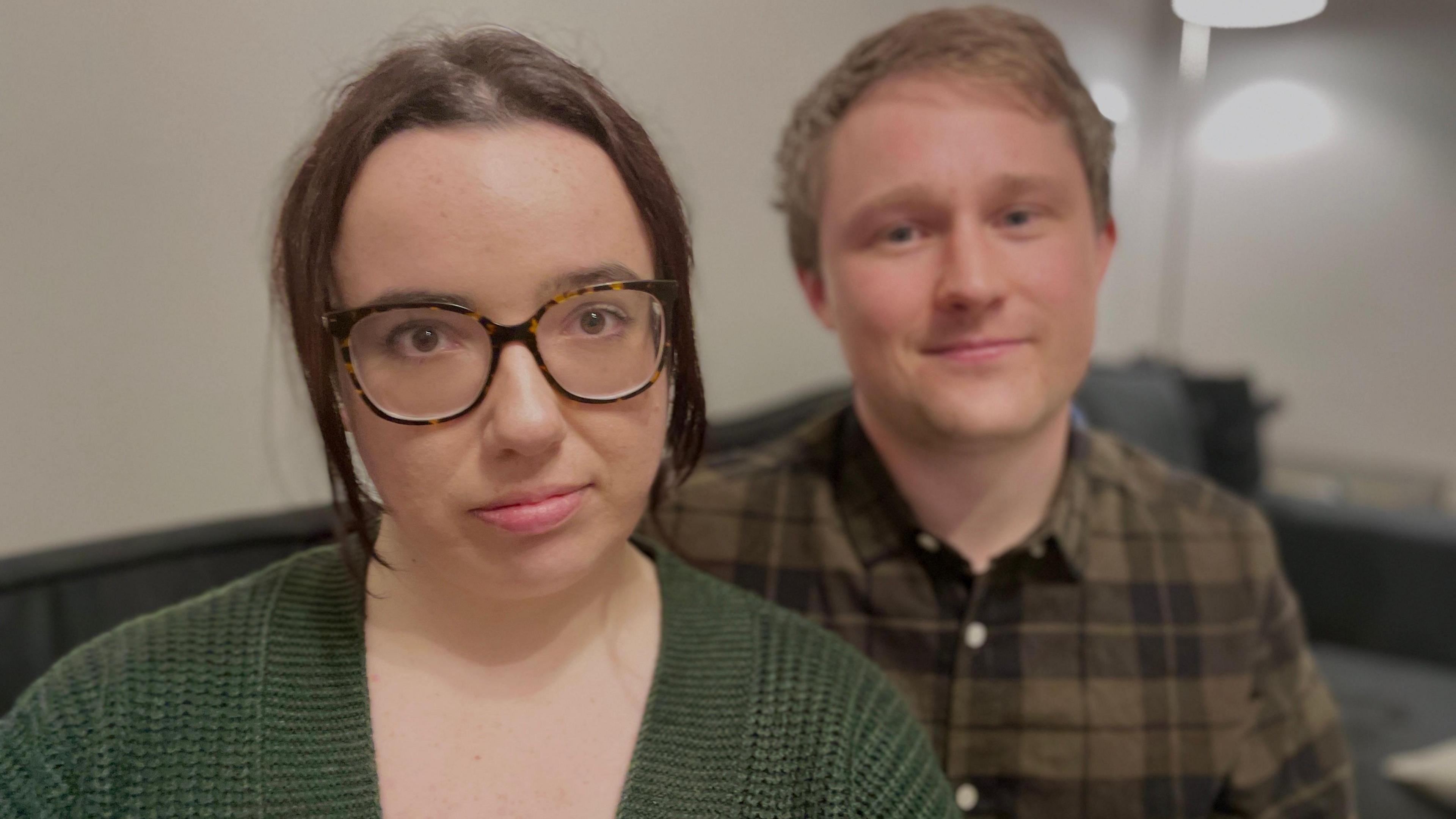 Mother Beth Cooper sitting close to the camera wearing a black blouse with her partner Tom Coxhead sitting just behind her.