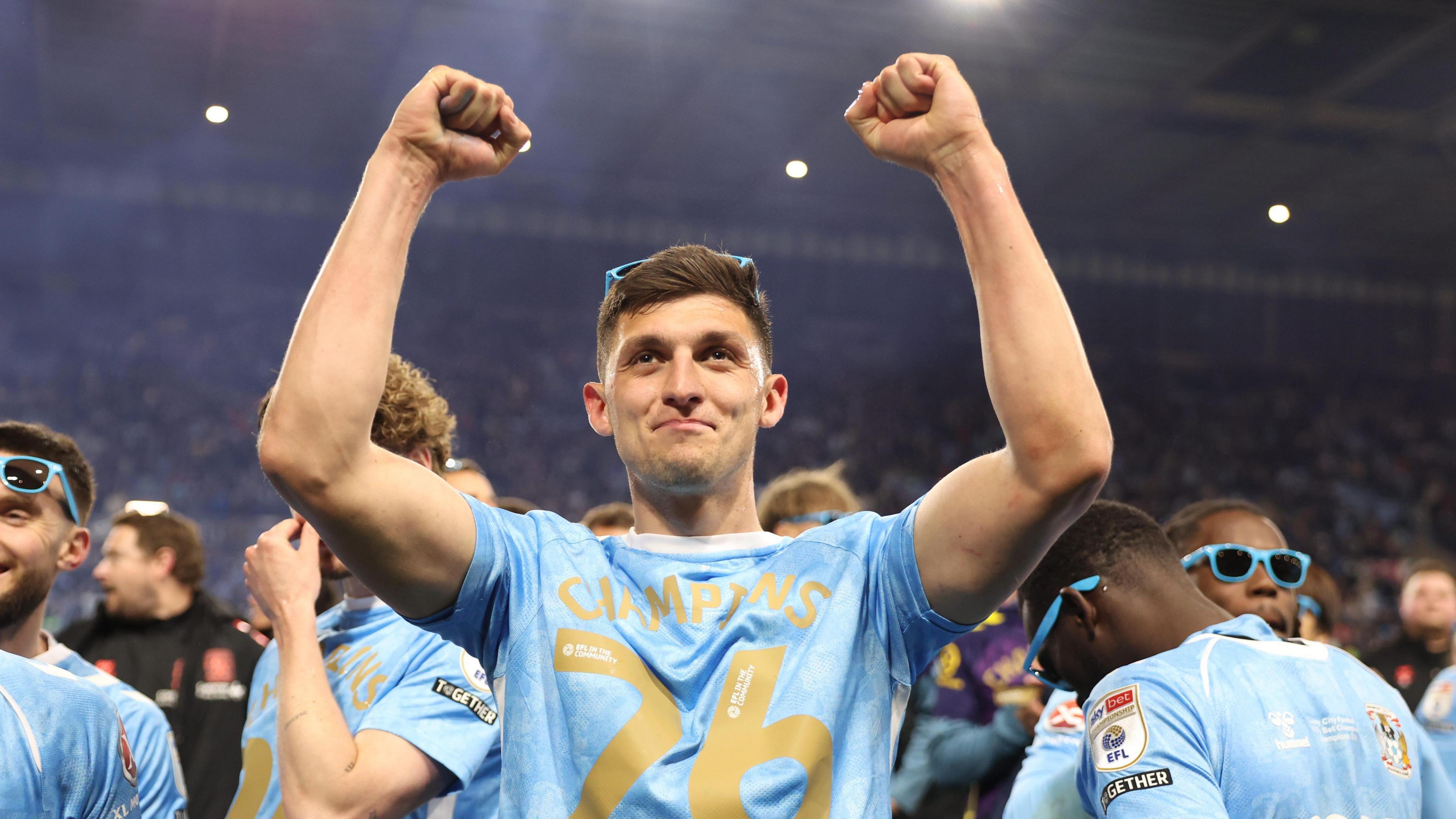 Coventry City defender Bobby Thomas with his two arms in the air clenched, celebrating his side's promotion to the Premier League.