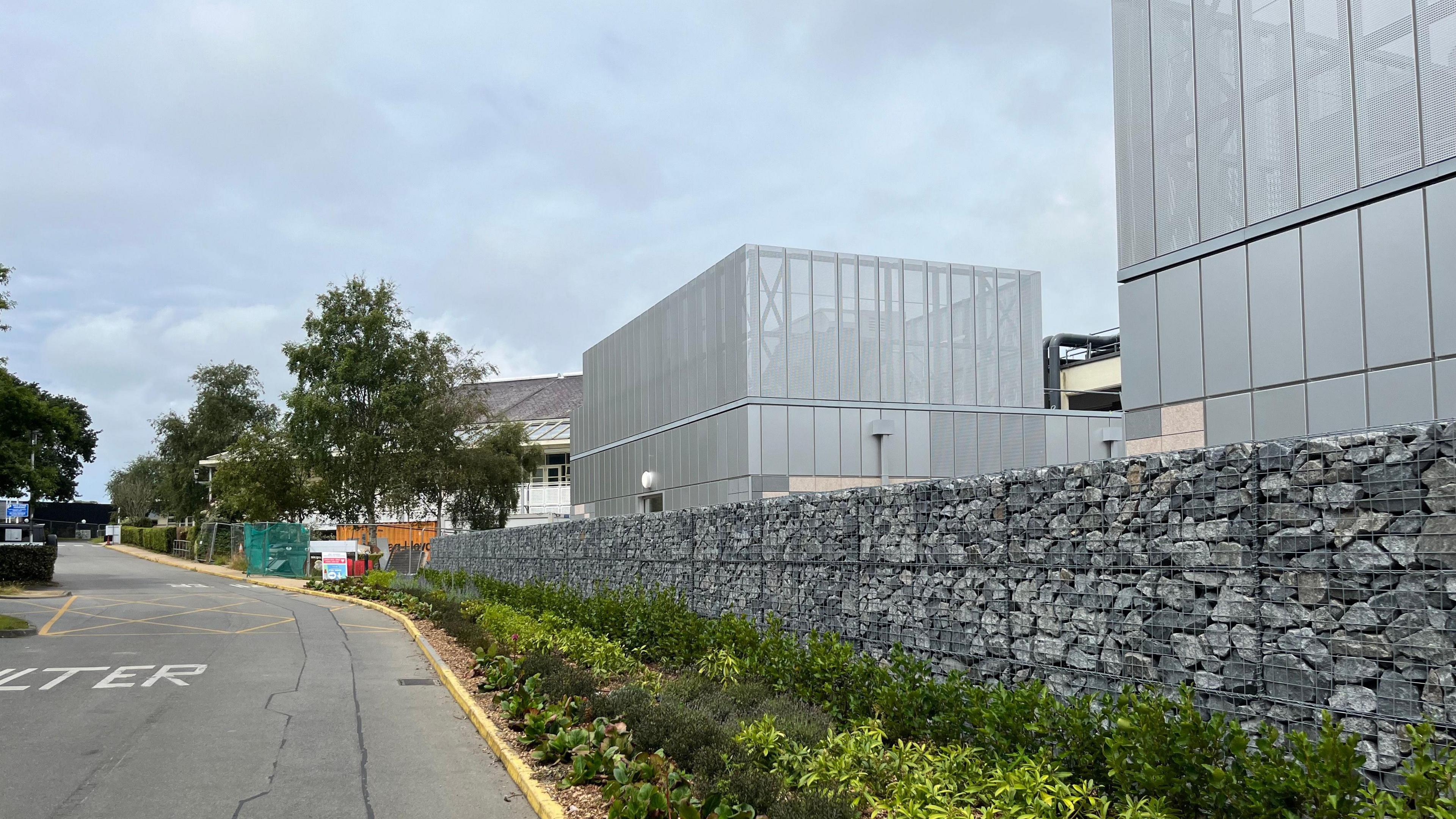 Guernsey's new Clinical Care Unit from the outside. A grey building with a granite wall outside.