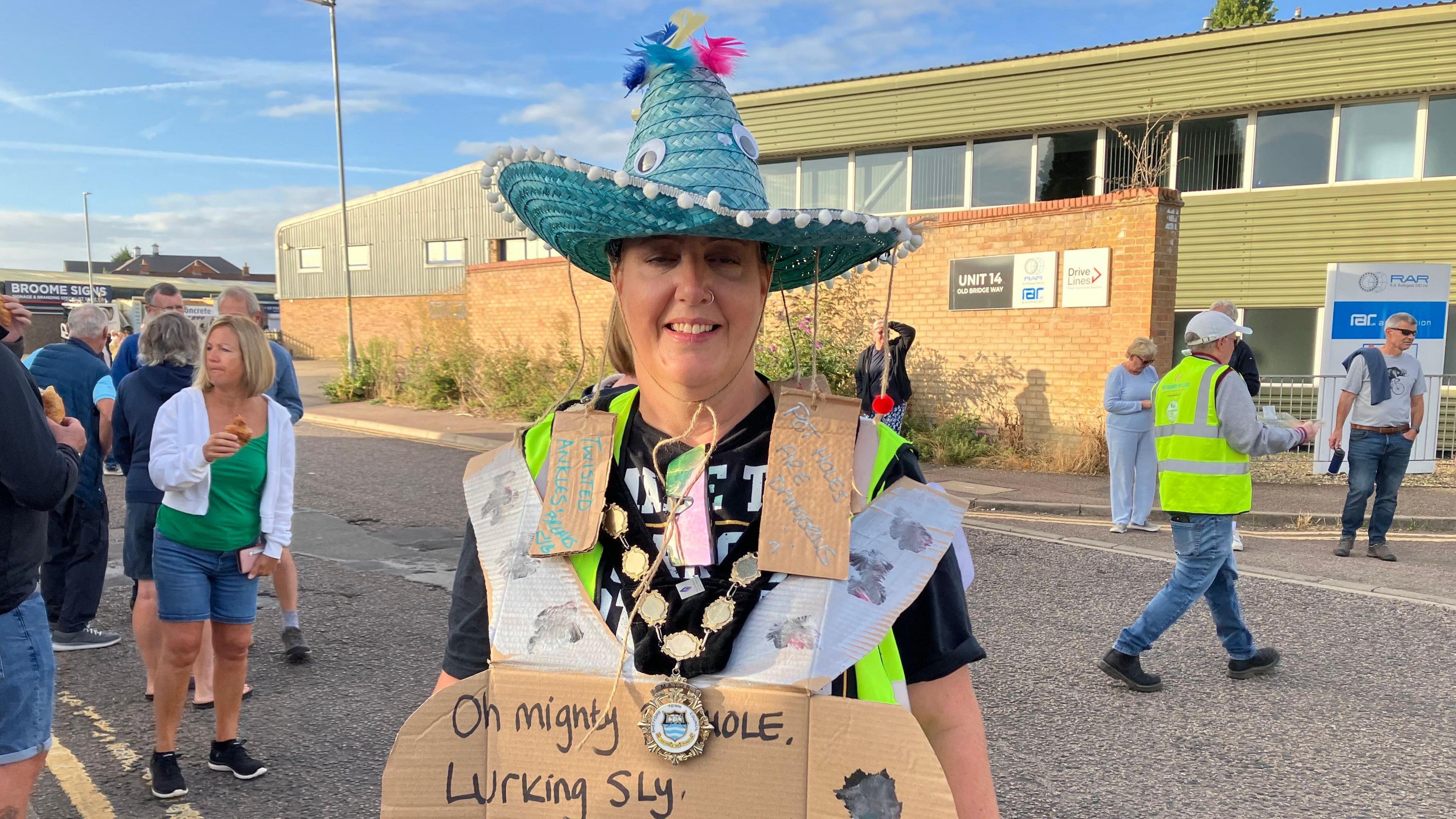 A picture of the Mayor of Shefford, Nicola King, in front of where the protestors were gathered on the road. She is wearing a Mexican sombrero hat, her mayoral chains and a few other slogans.