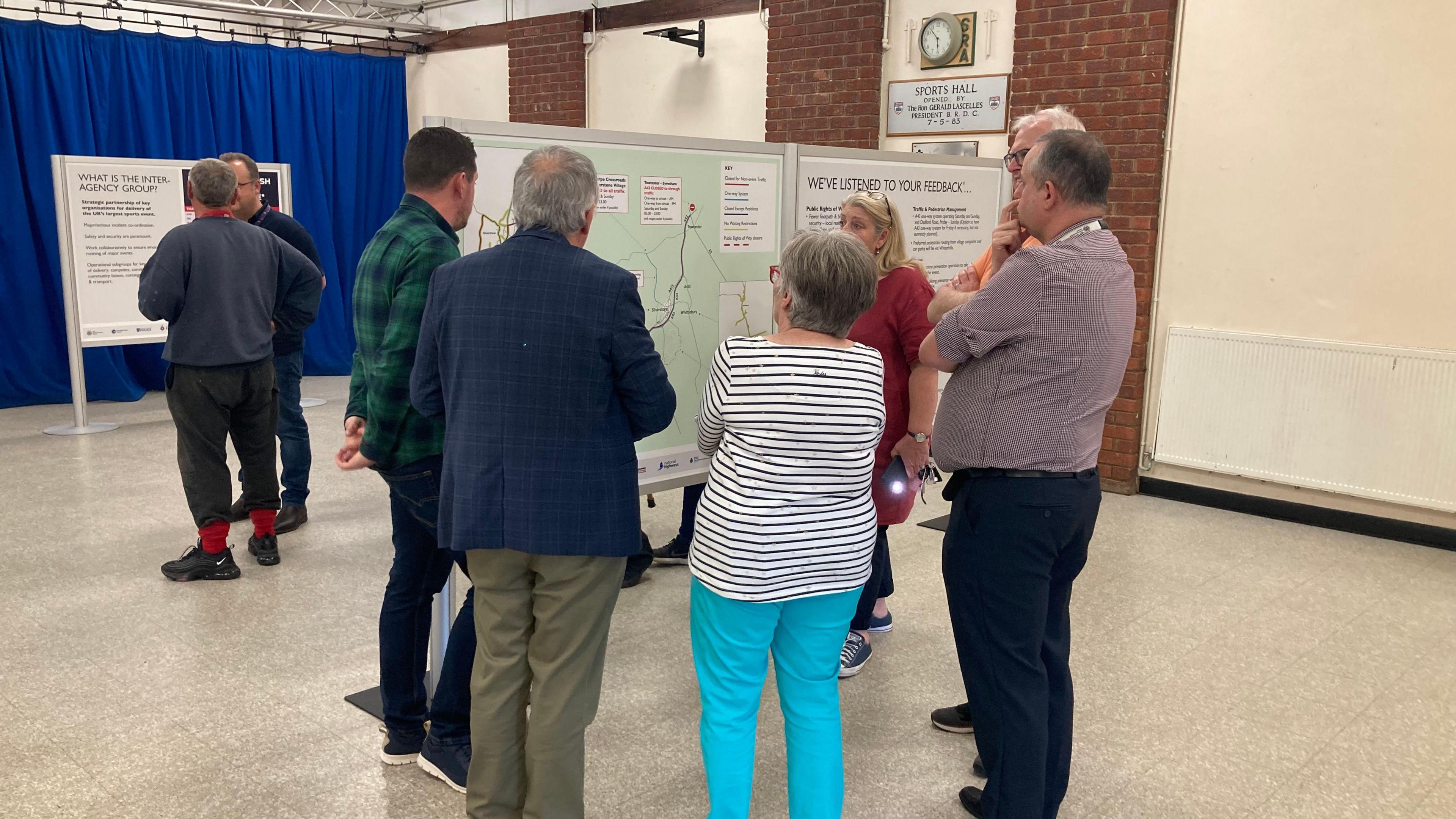 Residents and members of the Silverstone Parish Council gather around an information board 